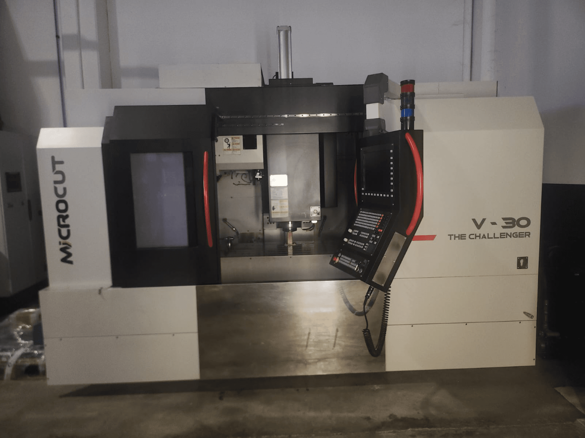 Microcut V-30 Die Challenger CNC-Maschine, Vorderansicht, mit Bedienfeld, Schneidbereich und industriellen Designelementen.