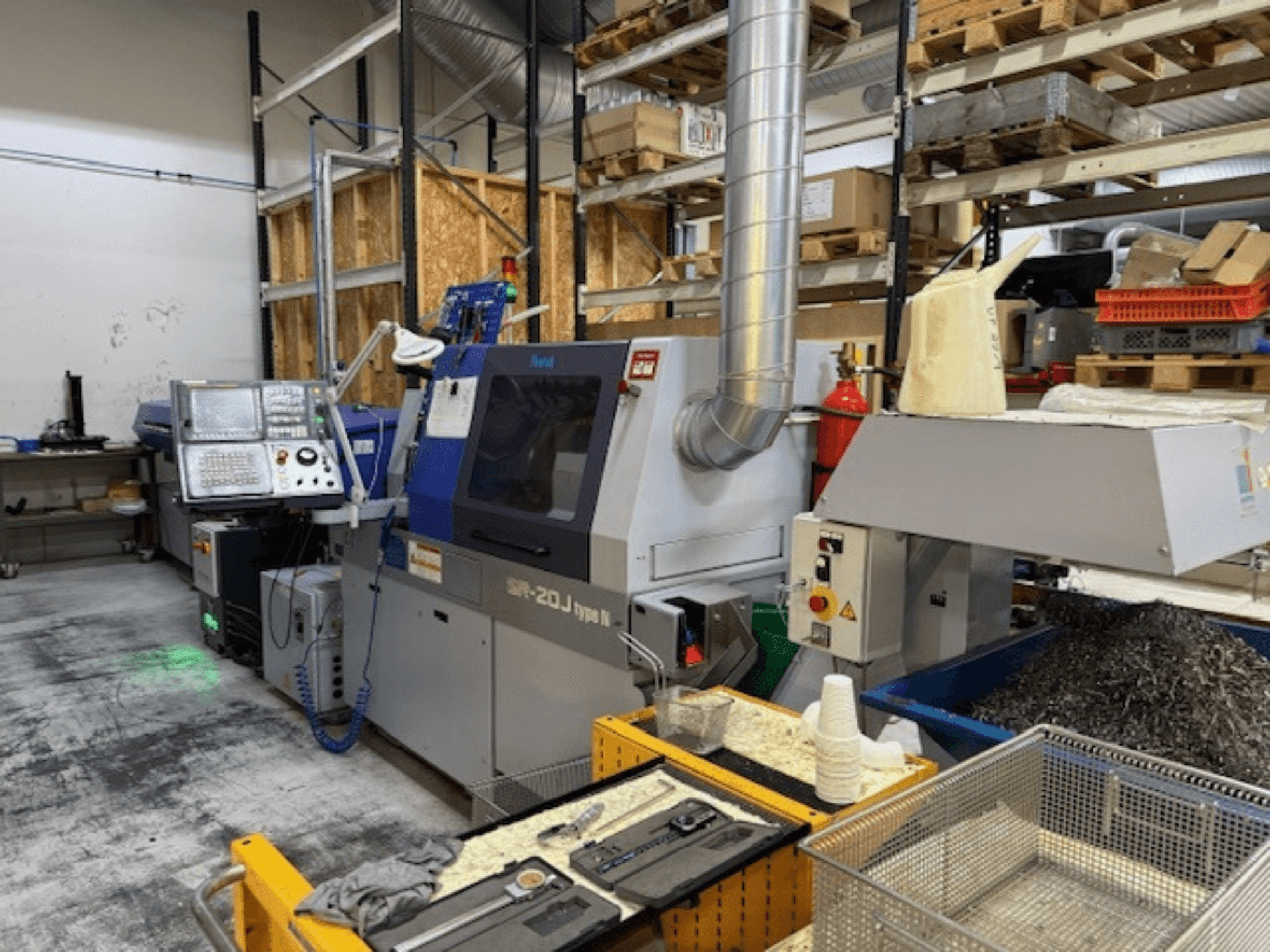 Vorderansicht eines Bearbeitungszentrums Faroh SPR-20J Typ N mit Bedienfeld, Metallspänen und Sicherheitsausrüstung in einer Werkstatt.