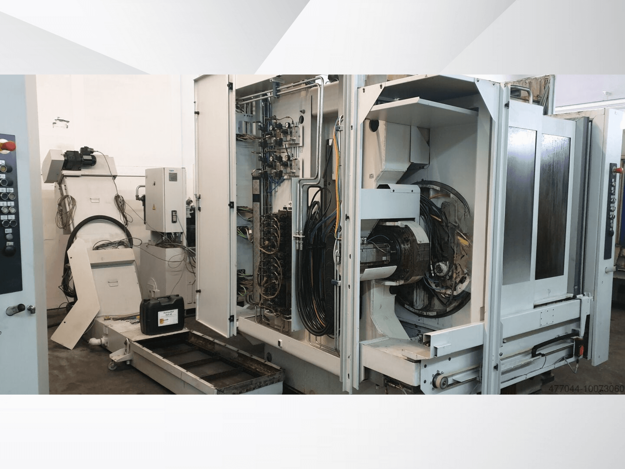 Industriemaschinen mit freiliegender Verkabelung, Schalttafel und mechanischen Komponenten; Seitenansicht einer komplexen Maschine.