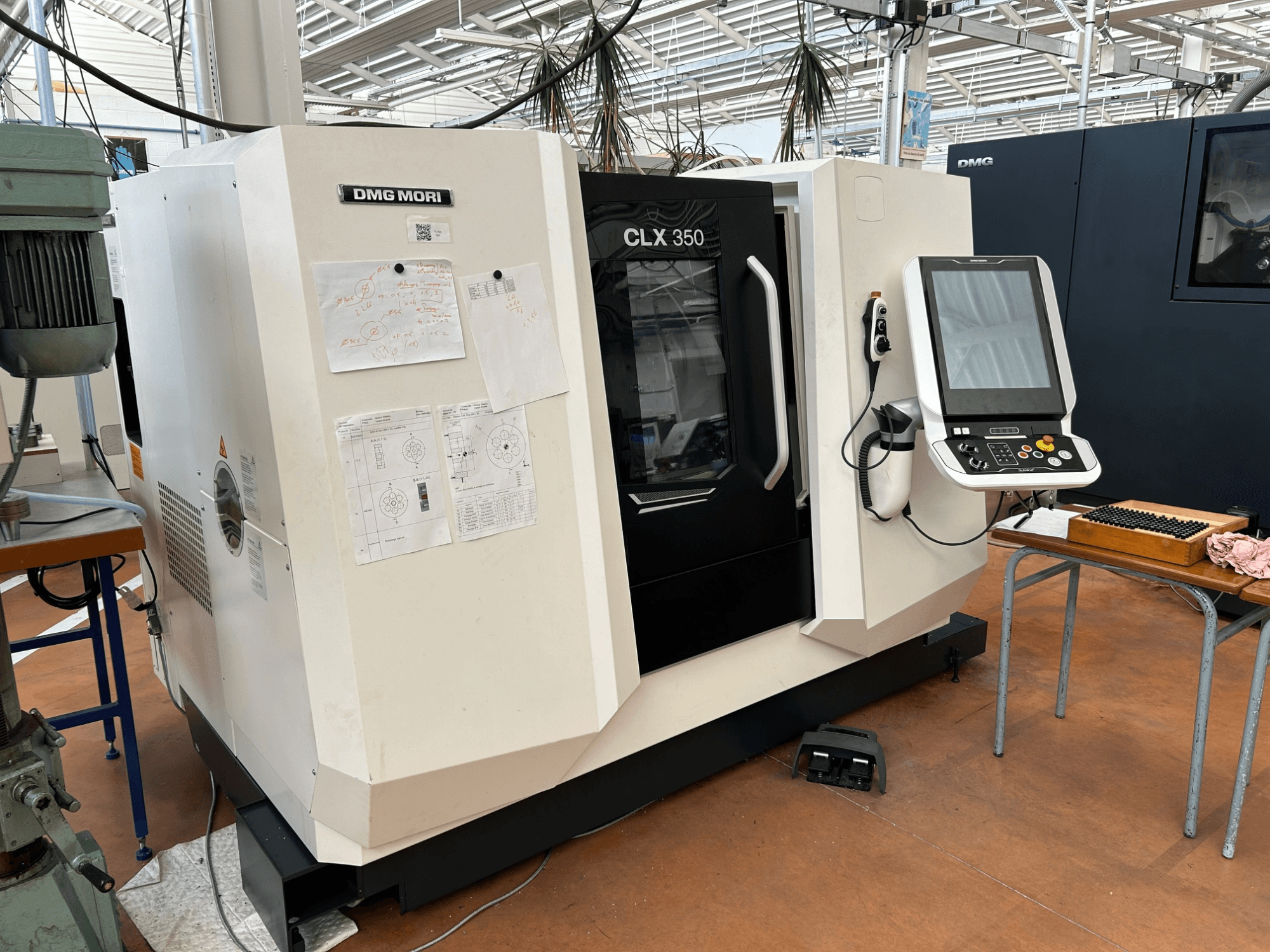 Horizontaldrehmaschine DMG MORI CLX 350 V4, Vorderansicht mit Bedienfeld und beigefügten technischen Unterlagen.