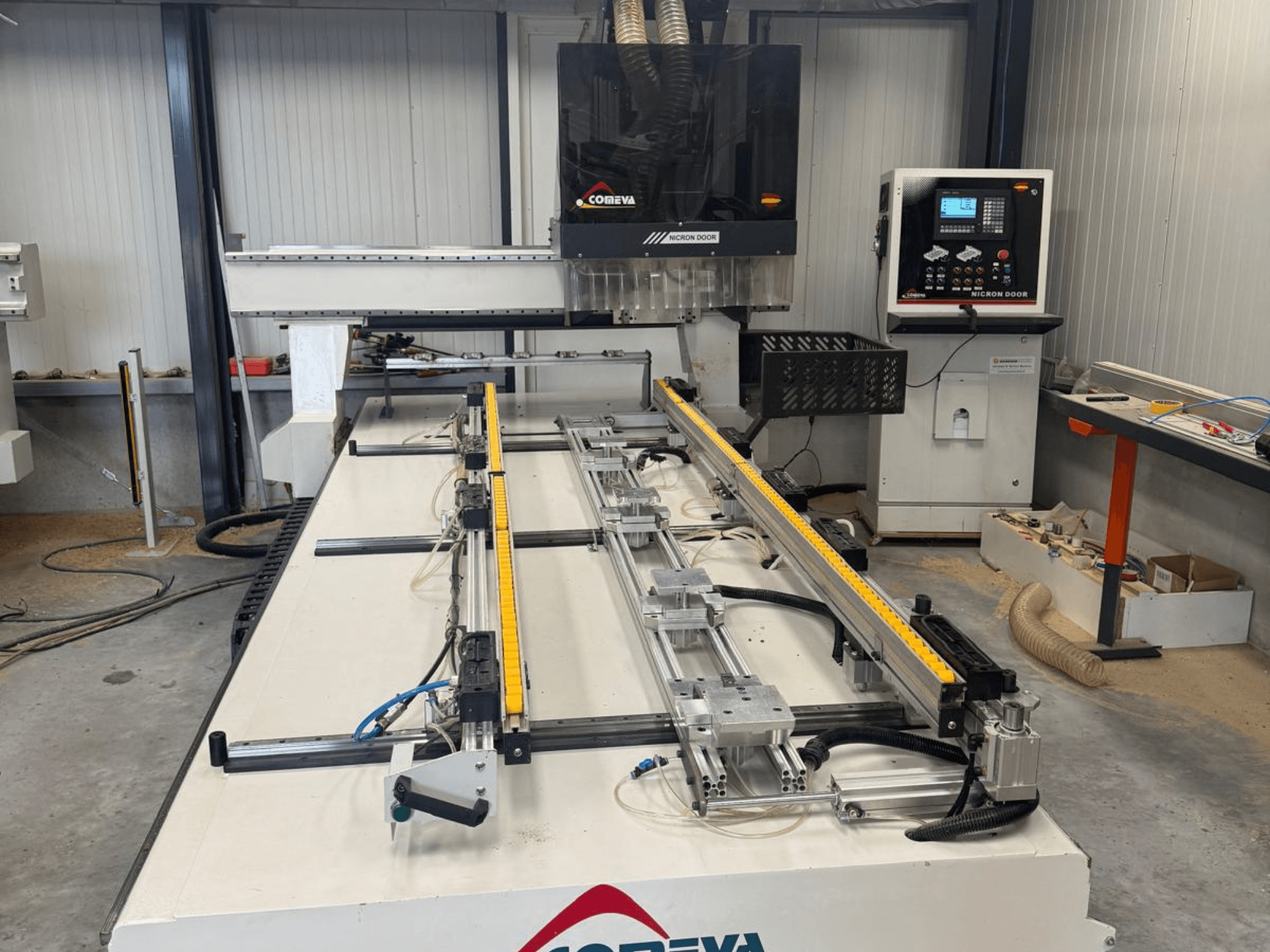 CNC-Holzbearbeitungszentrum COMEVA MEX V 2100x3260, Vorderansicht, mit Arbeitsstation, Bedienfeld und Führungsschienen.