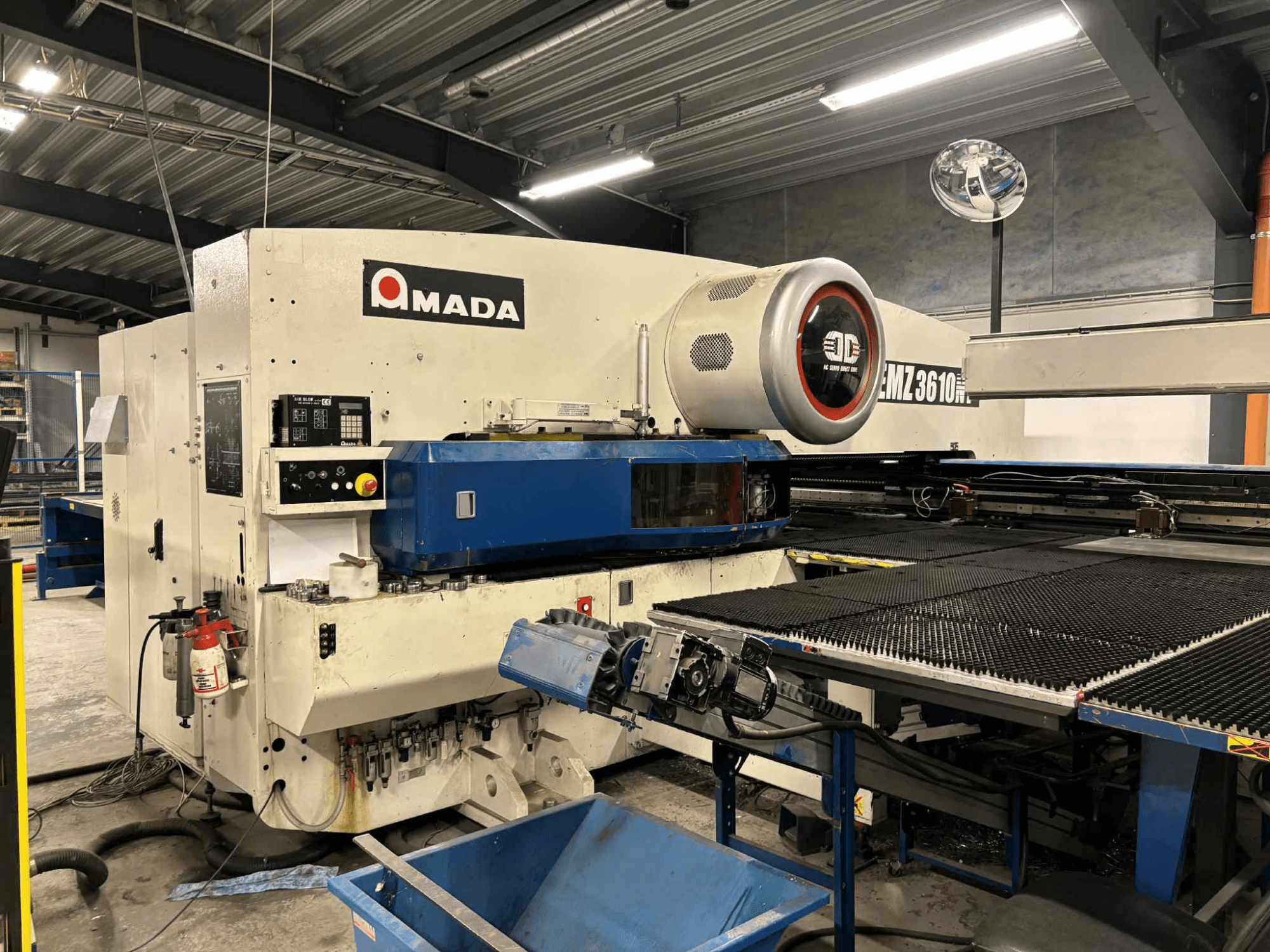 Amada EMZ3610H Stanzpresse von vorne gesehen; mit Bedienelementen, blauem Bett und Sicherheitseinrichtungen.