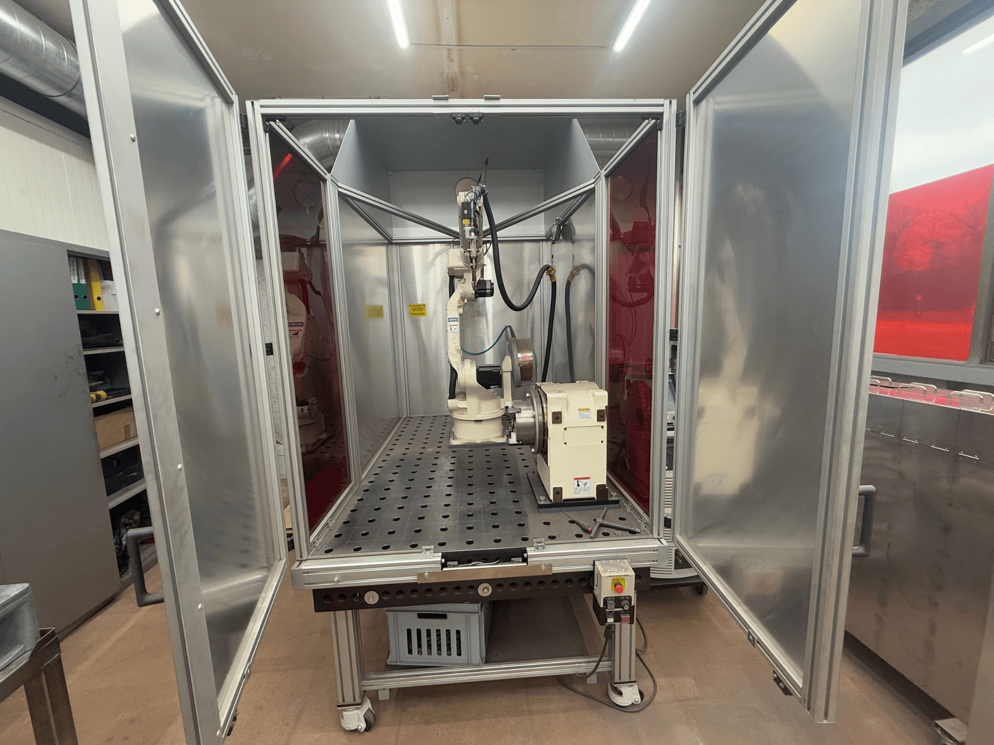Schweißroboter OTC Daihen EASY ARC V02.04 in einem Metallgehäuse, von vorne gesehen, mit Gelenkarm und Bedienfeld.