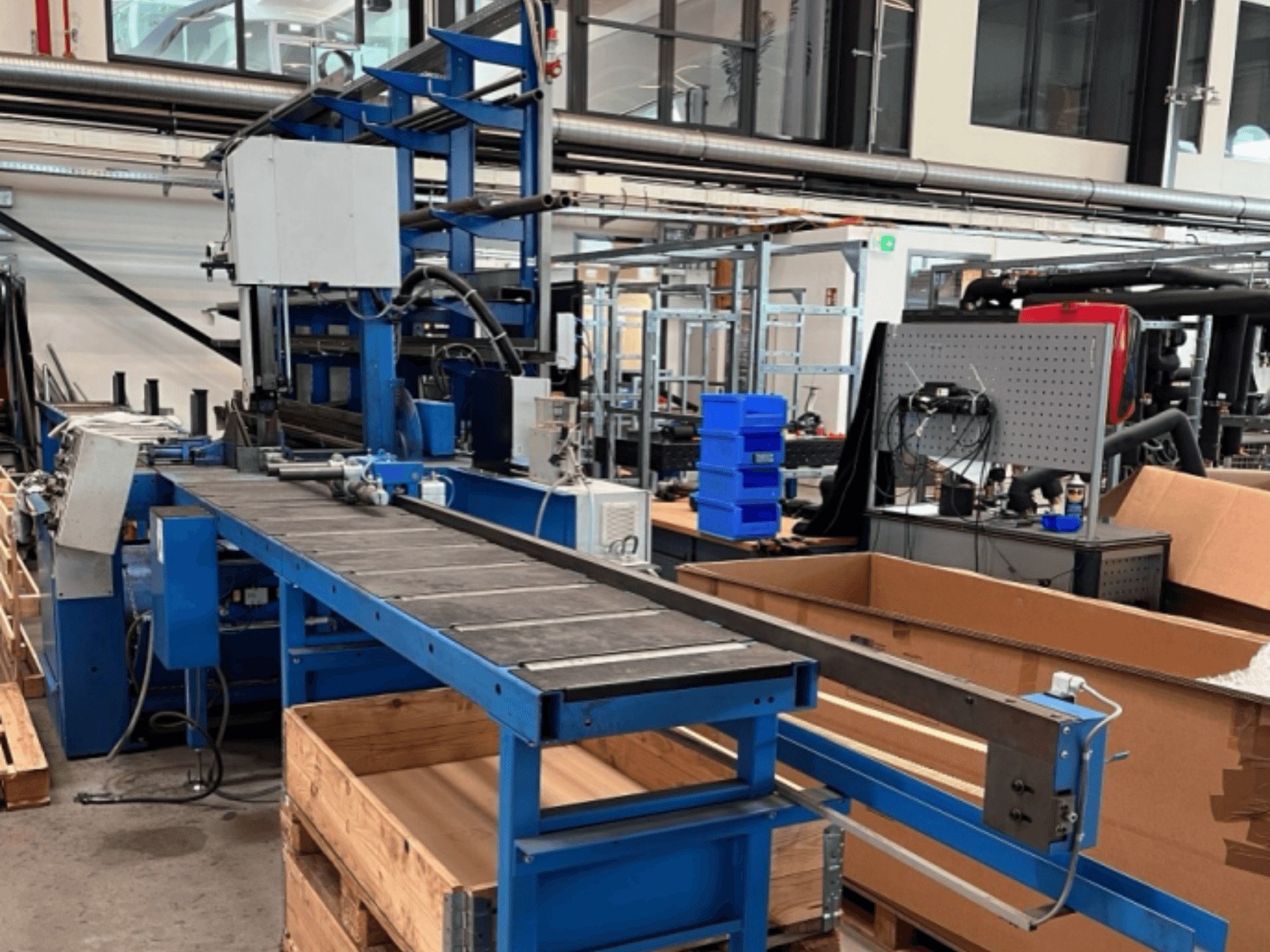 Metallbandsäge vom Typ JAESPA Classic 423 DGH, von vorne gesehen, mit Förderband und umgebenden Industrieanlagen.