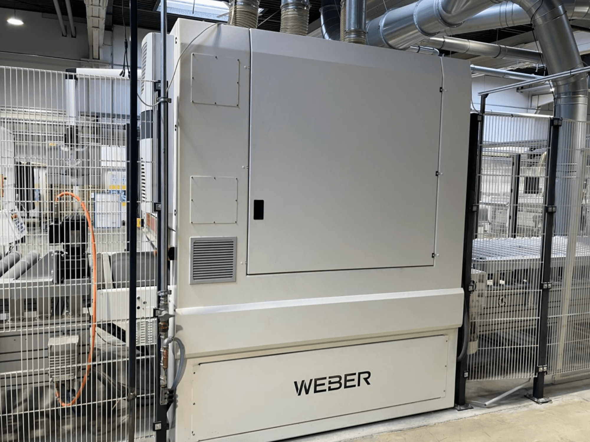Frontansicht der HYMMEN JUPITER JPT C 680/548 Holzproduktionslinie mit WEBDER Komponente und sichtbarer Sicherheitsumzäunung.