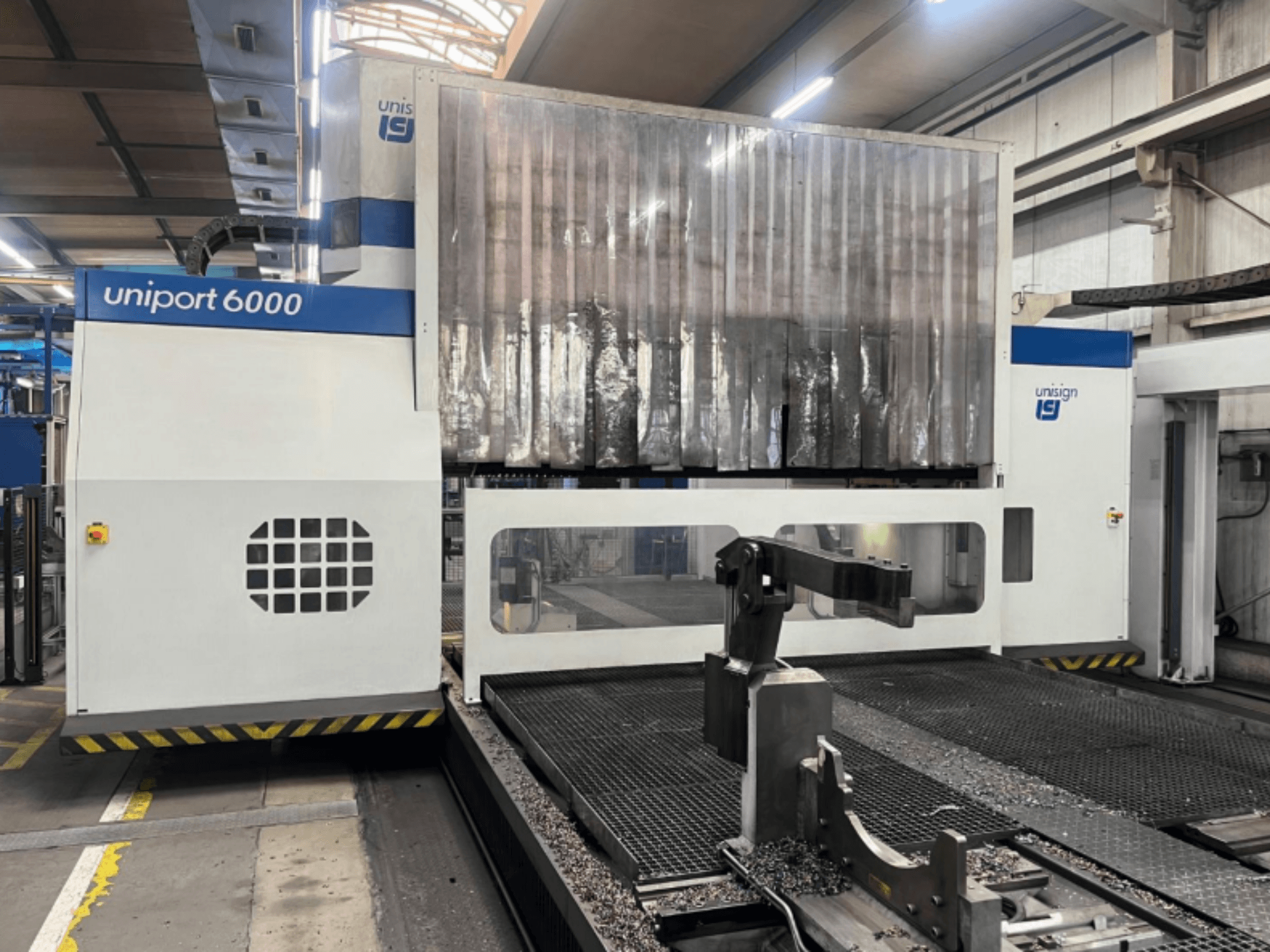 Portalfräsmaschine Unisign uniport 6000, Vorderansicht, zeigt die Maschinenstruktur und den Schneidbereich mit Metallspänen.