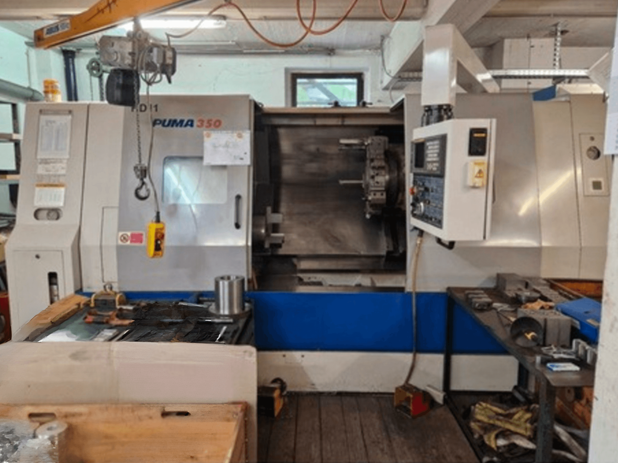 DAEWOO Puma 350 Horizontal-Drehmaschine, Seitenansicht, mit Bedienfeld und Arbeitsbereich mit Werkzeugen und Materialien in der Nähe.