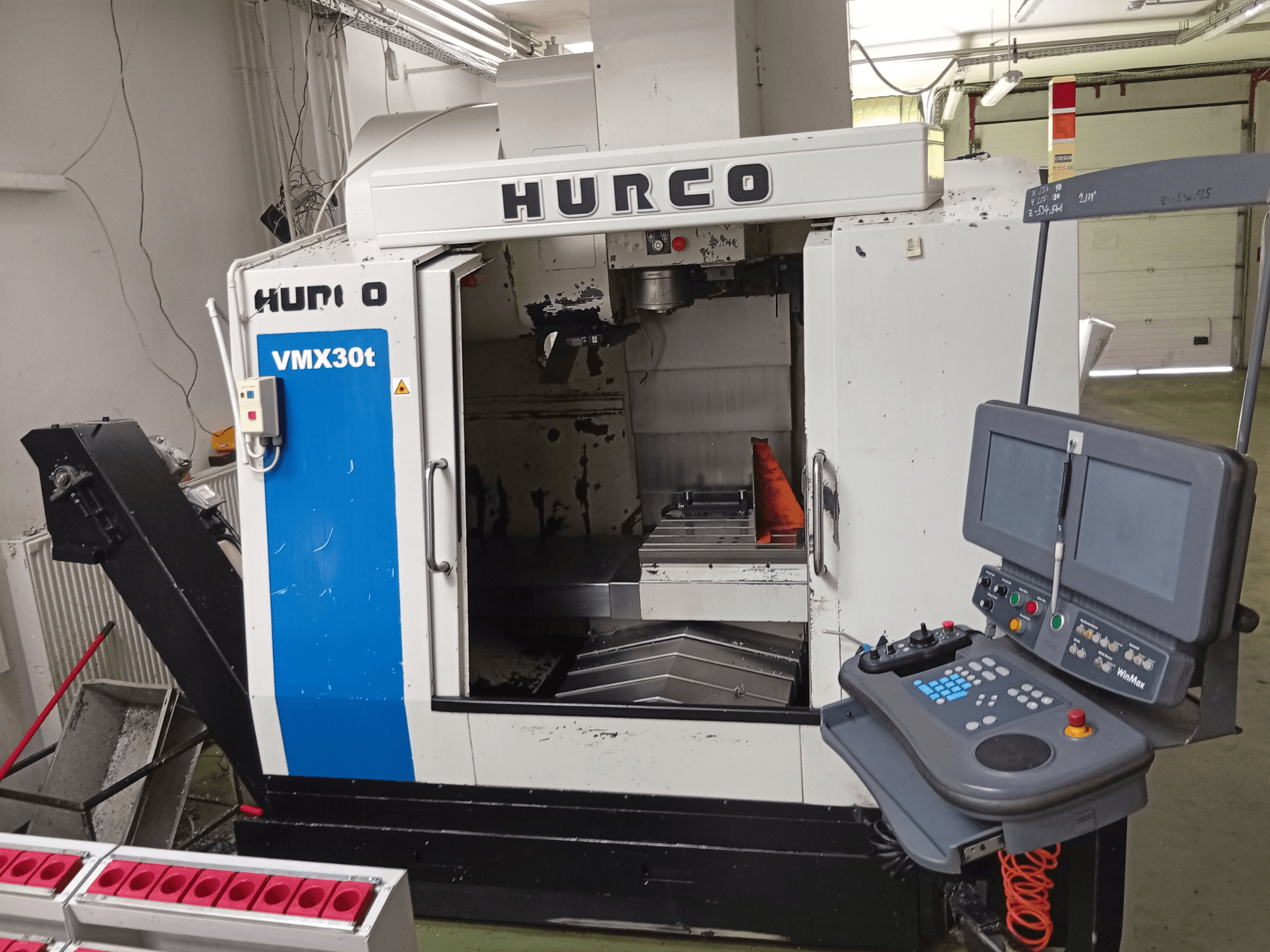 Vertikales Bearbeitungszentrum Hurco VMX 30T, Vorderansicht, mit Bedienfeld und Spindelbereich sowie sichtbarem Arbeitstisch.