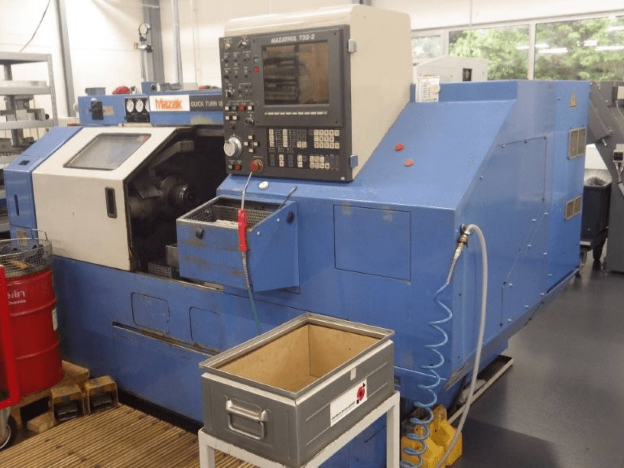 Mazak Quick Turn 18 NSP Mehrspindeldrehmaschine, Vorderansicht, mit Bedienfeld, Arbeitsbereich und Kühlmittelschlauch.