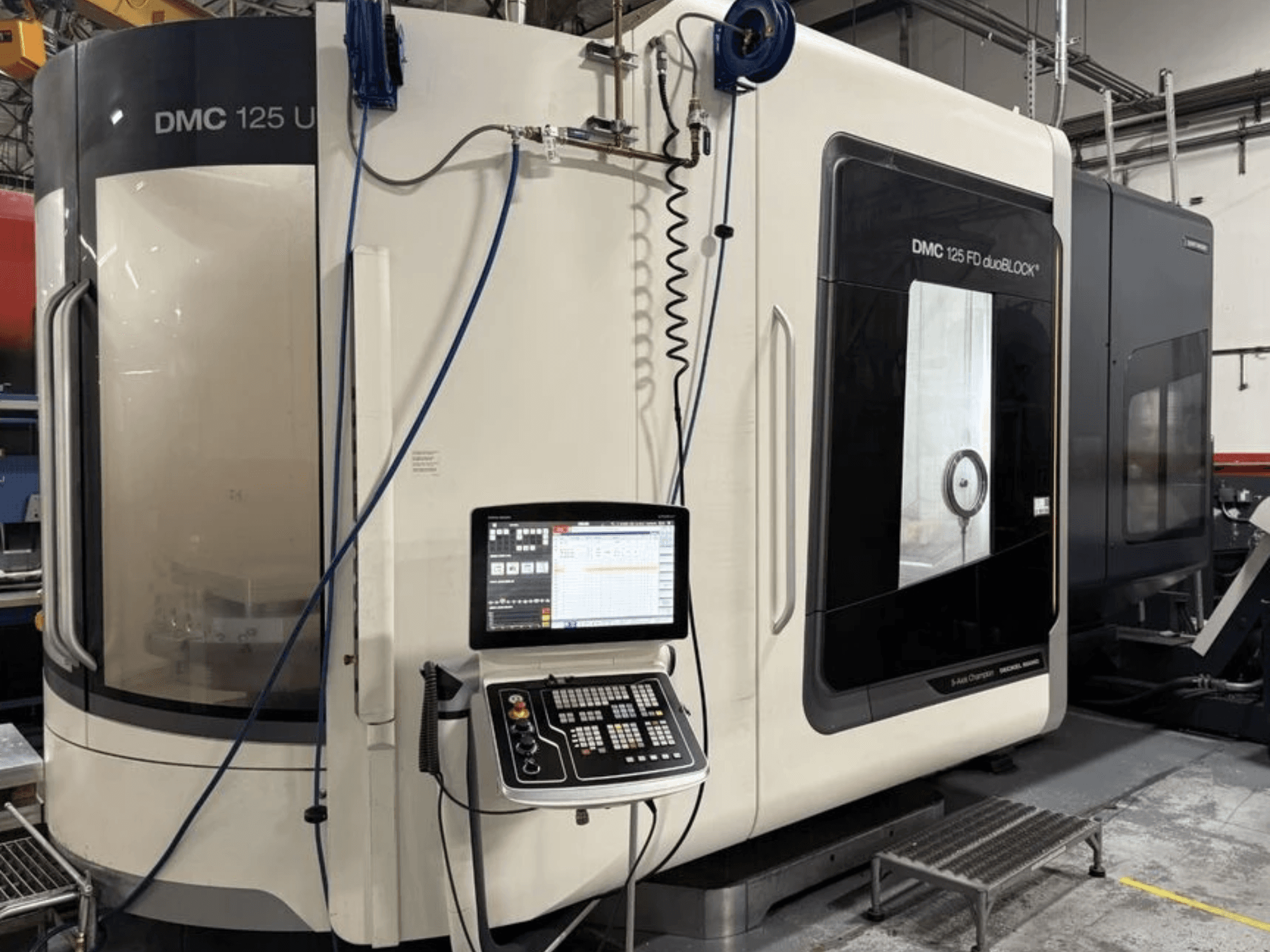 Universelles Bearbeitungszentrum DMG MORI DMC 125 U duoBLOCK, Vorderansicht mit Bedienfeld und reflektierenden Oberflächen.