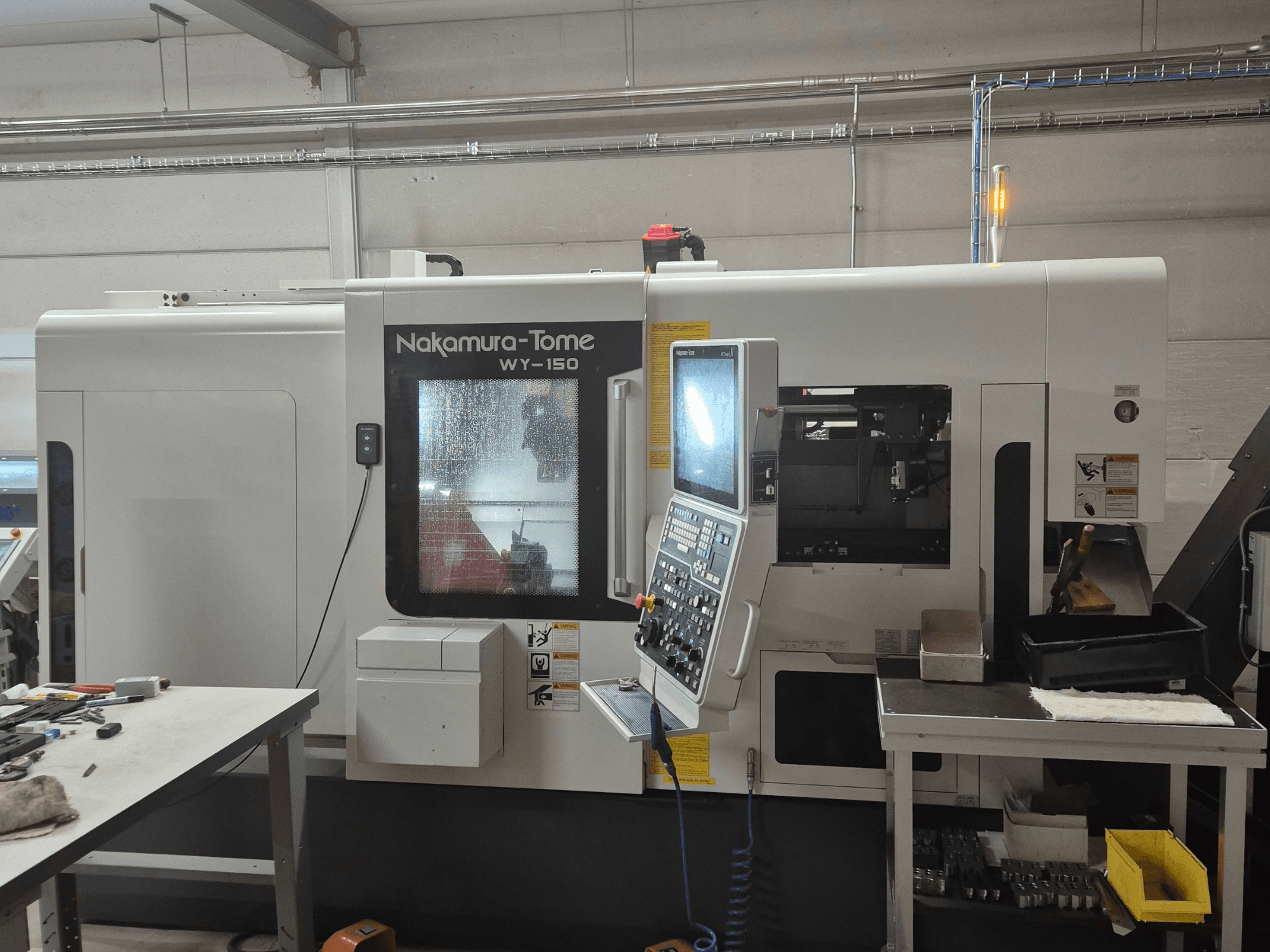 Nakamura-Tome WY-150 CNC-Drehmaschine in der Seitenansicht, mit Bedienfeld, Sichtfenster und sichtbarem Arbeitsbereich.