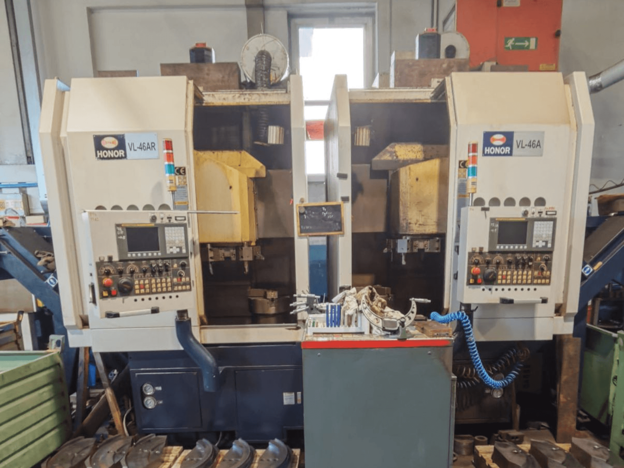 Vertikaldrehmaschine HONOR SEIKI VL 46 AR mit zwei Arbeitsstationen, Vorderansicht mit Bedienfeldern und Werkzeugen.