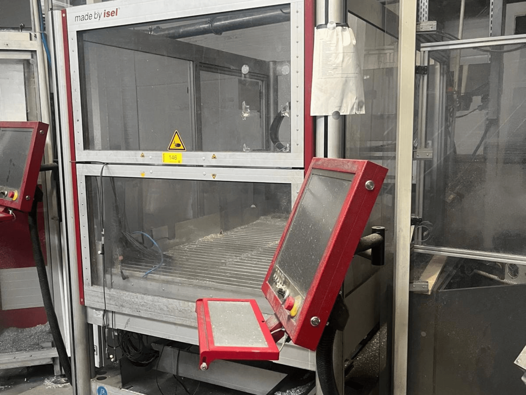Vertikales Bearbeitungszentrum ISEL FLATCOM M 30, Vorderansicht mit Bedienfeld, Arbeitsbereich und Sicherheitsvorrichtungen.