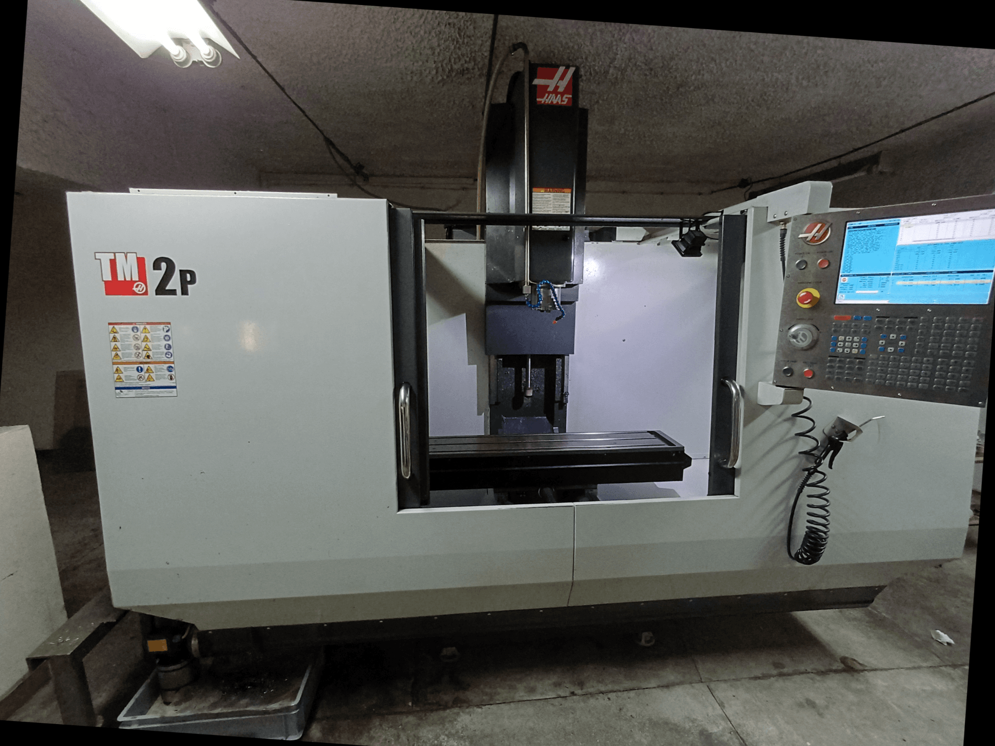 HAAS TM-2P Vertikal-Bearbeitungszentrum, Vorderansicht, mit Bedienfeld, Spindelkopf und Maschinenbett.