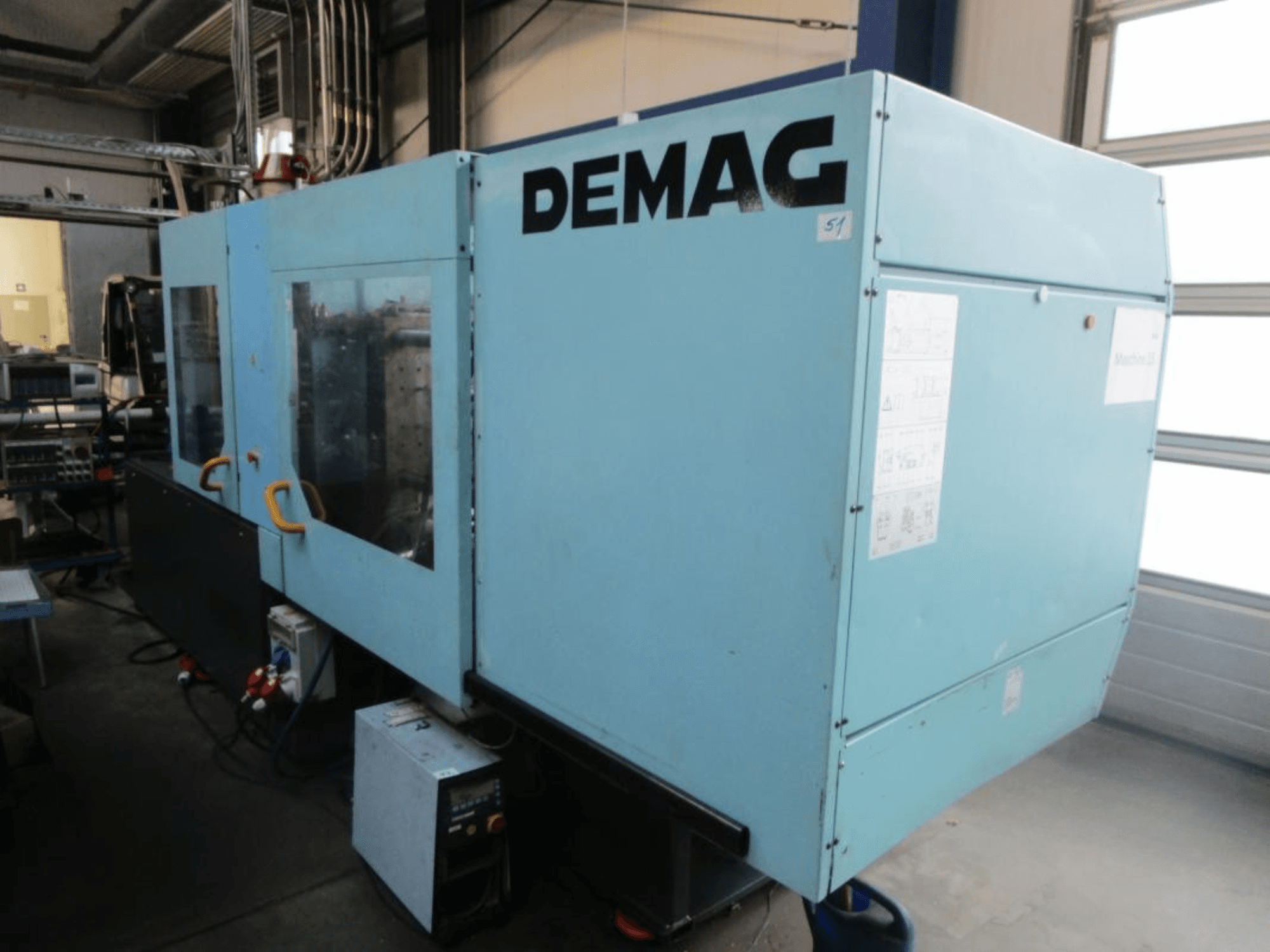 Vorderansicht einer hydraulischen Spritzgießmaschine vom Typ DEMAG Ergotech 150-610 Viva mit sichtbarem Bedienfeld und Griffen.