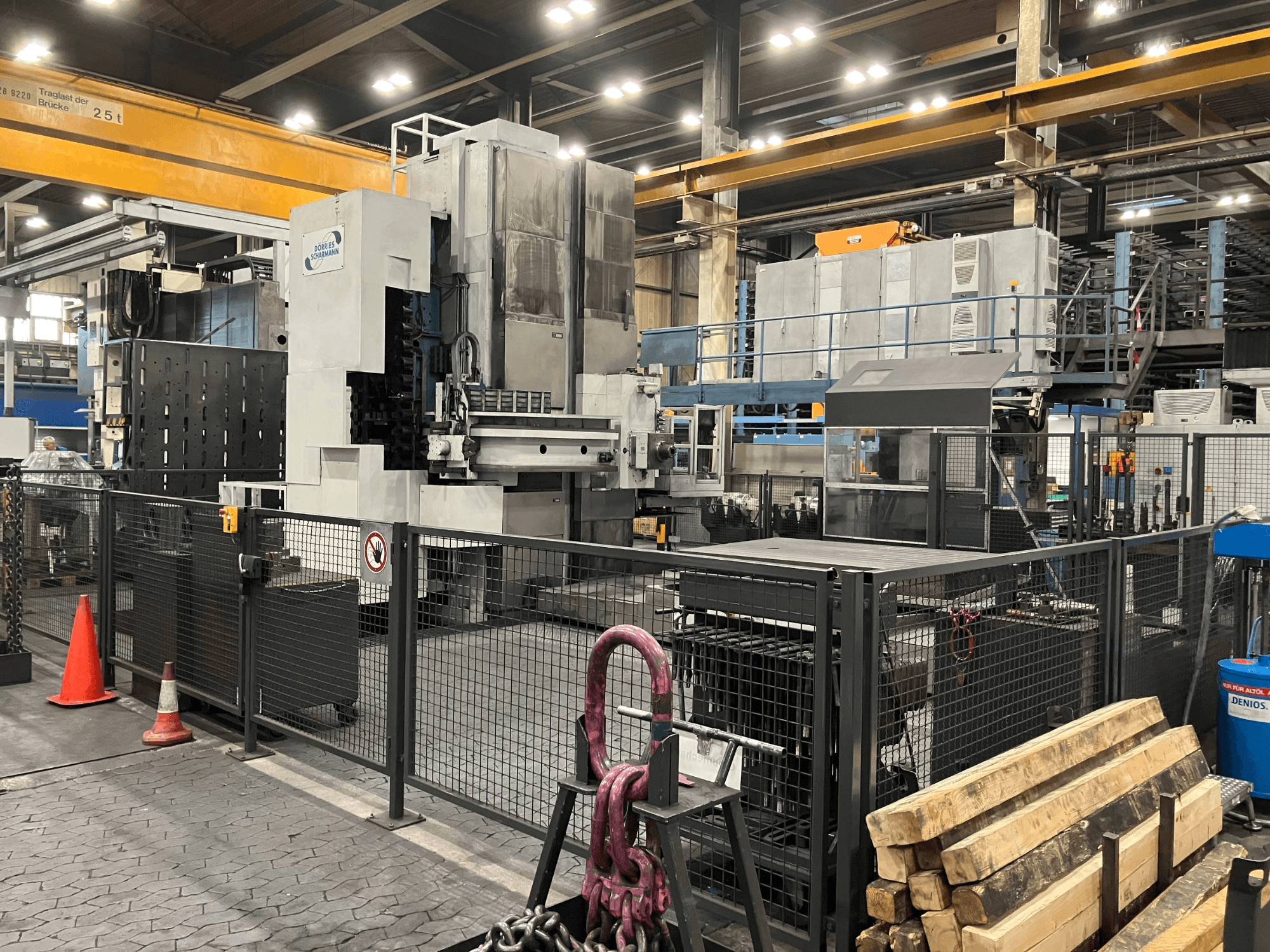 Bohrmaschine DÖRRIES SCHARMANN Heavycut 1.2 TDV4 in einer Werksumgebung, Seitenansicht mit Schutzzäunen und Werkzeugen in der Nähe.