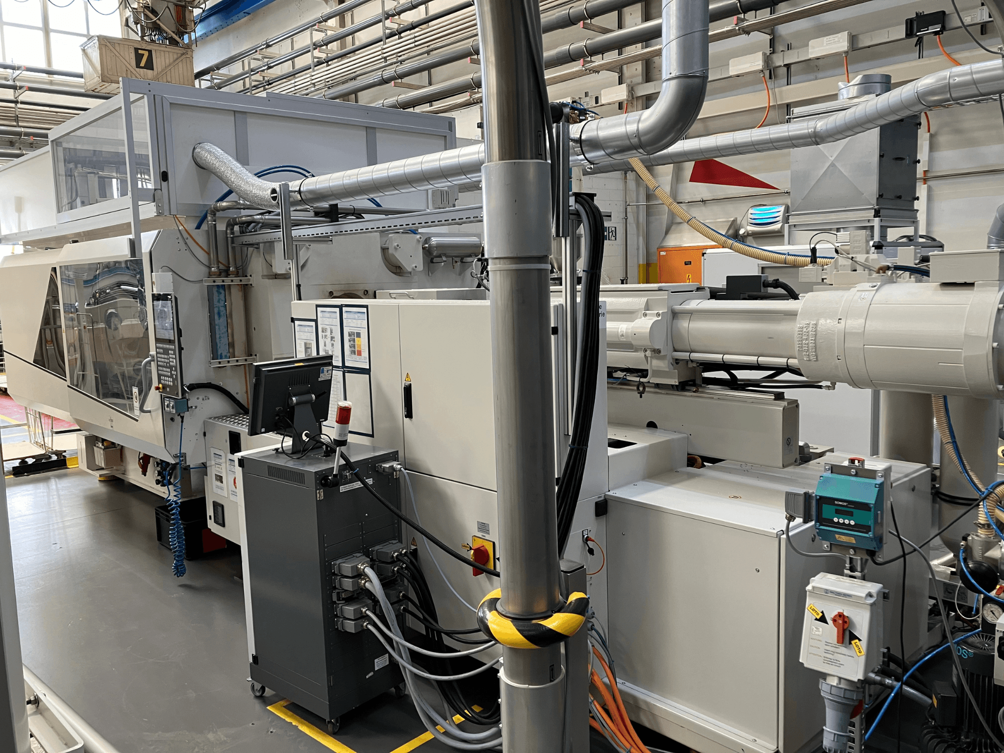 Industriemaschine mit Bedienfeld, Vorderansicht, mit Rohren, elektrischen Komponenten und Sicherheitseinrichtungen.