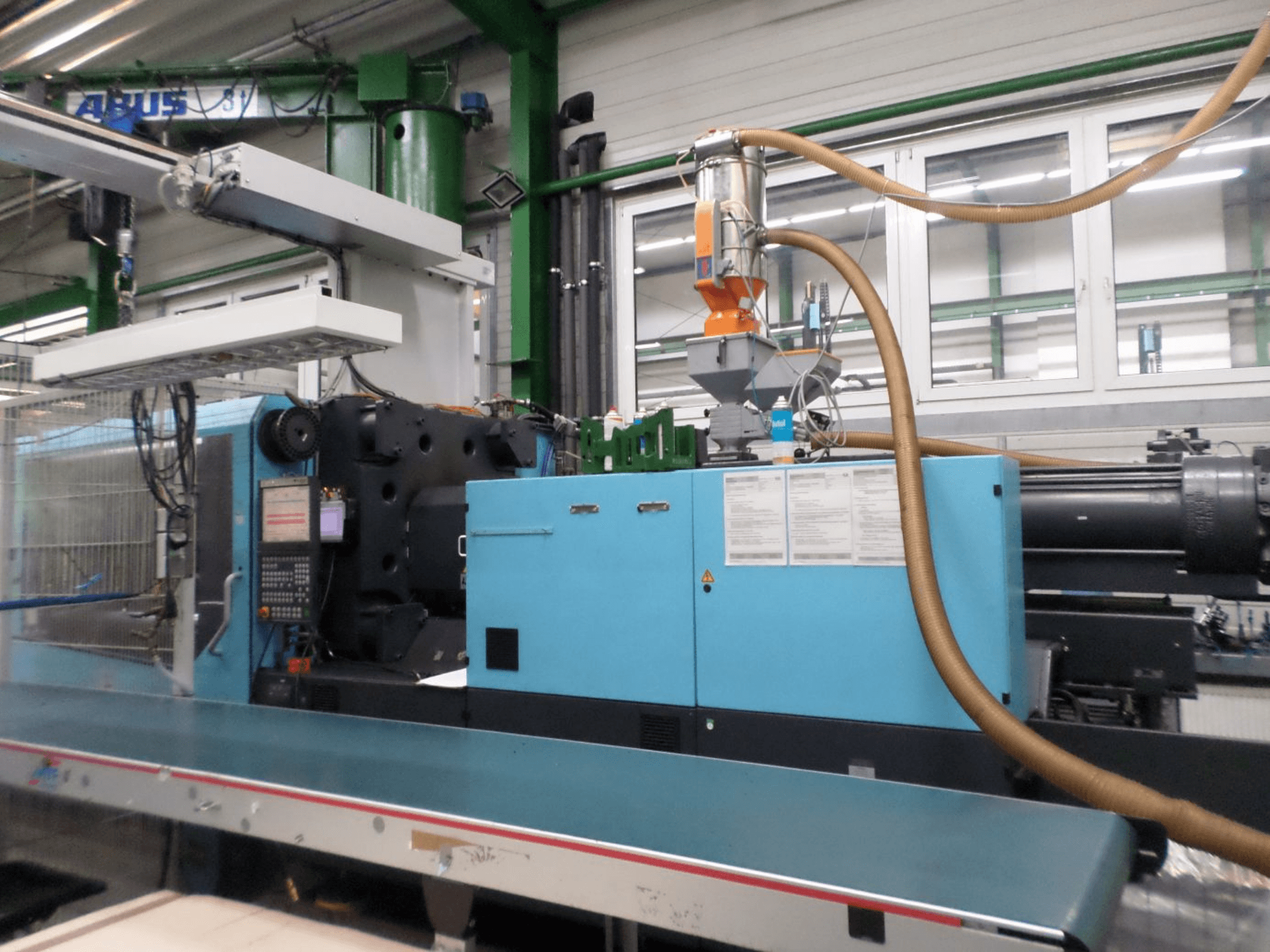 Vorderansicht einer hydraulischen DEMAG D 420-Spritzgießmaschine mit Bedienfeld, Trichter und Hydraulikkomponenten.