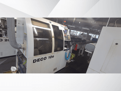 DECO 10e Maschine in einer Werkstatt; Seitenansicht mit Bedienfeld und Lüftungsschlauch, im Hintergrund unscharfe Maschinen.