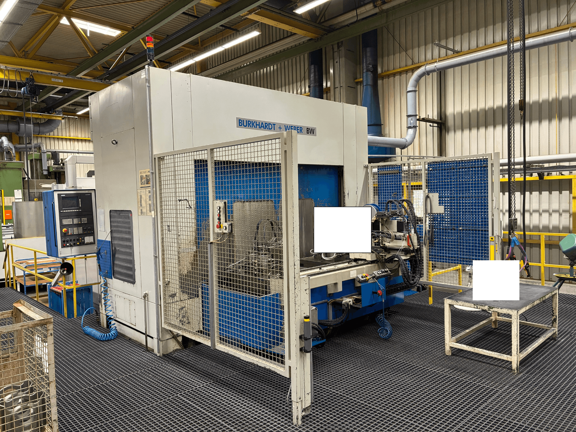 Burkhardt + Weber BW-Bearbeitungszentrum, Frontansicht, mit Bedienpult und Sicherheitsumhausung, in Industrieumgebung.