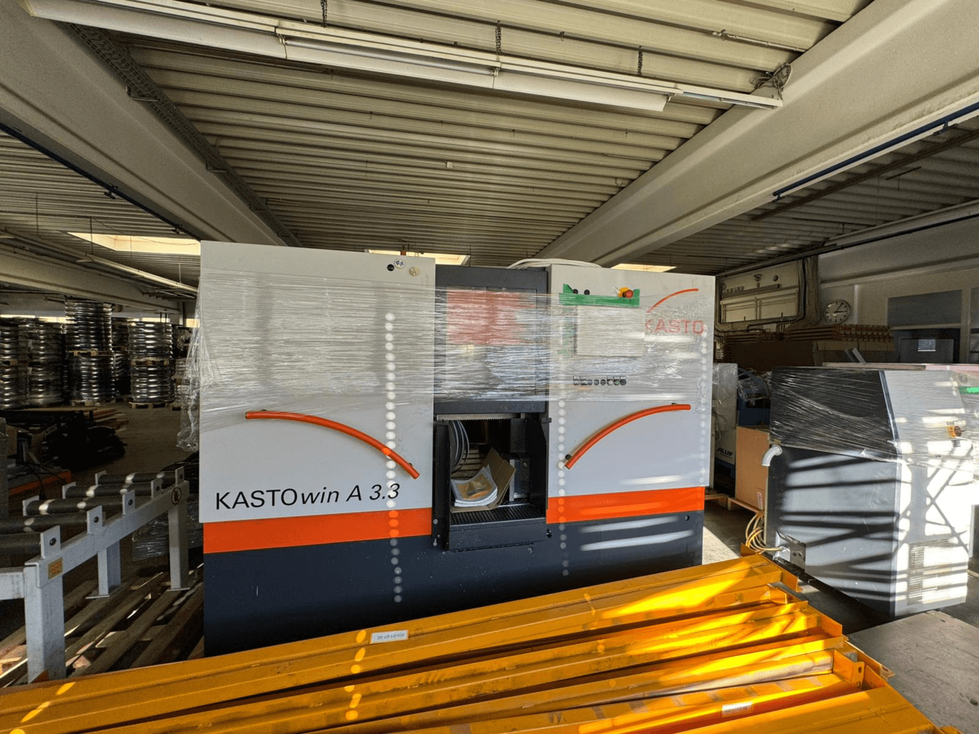 KASTO win A 3.3 Metallbandsäge in Frontansicht, zum Schutz verpackt, wobei die Bedienelemente und die umgebende Ausrüstung sichtbar sind.