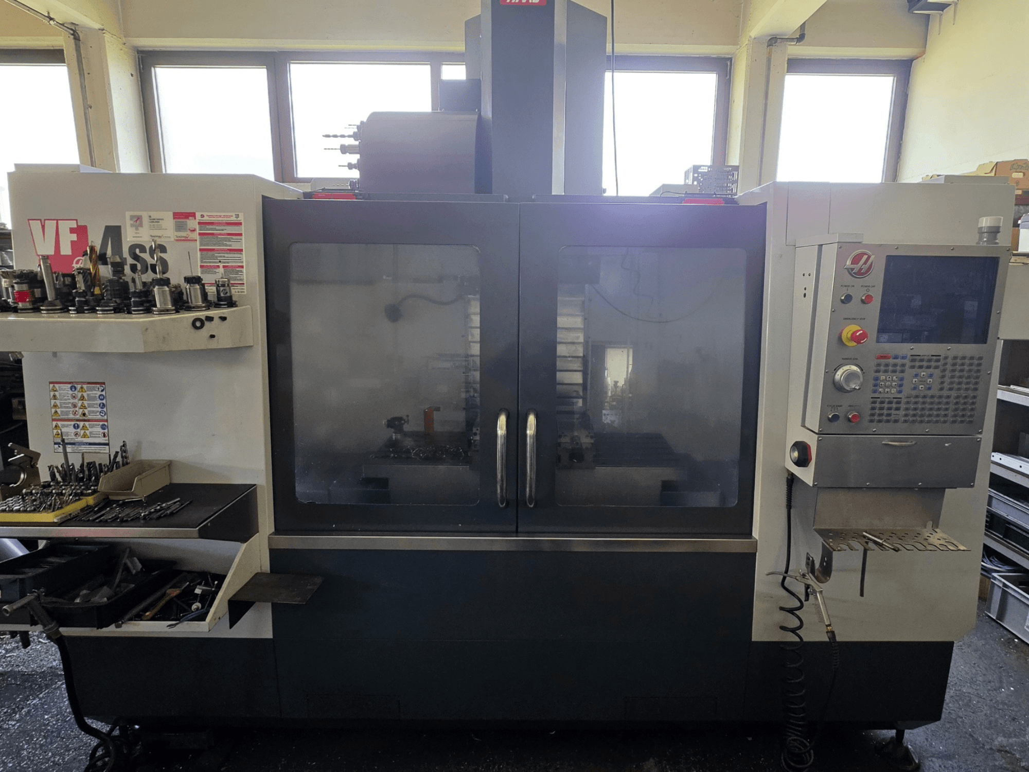HAAS VF 34SS Vertikal-Bearbeitungszentrum in der Frontansicht mit Bedienfeld und Werkzeugablage.