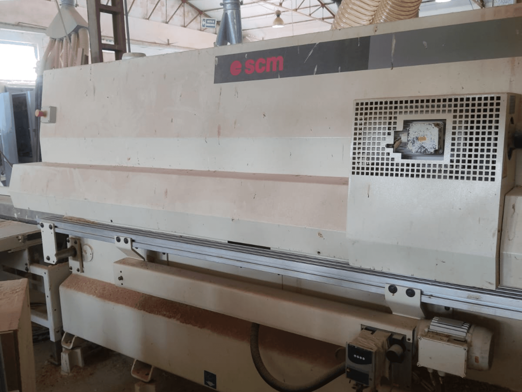CNC-Holzbearbeitungszentrum SCM Windor60, Vorderansicht. Zu sehen sind die Maschinensteuerung und die Absauganlage, darunter liegen Holzspäne.