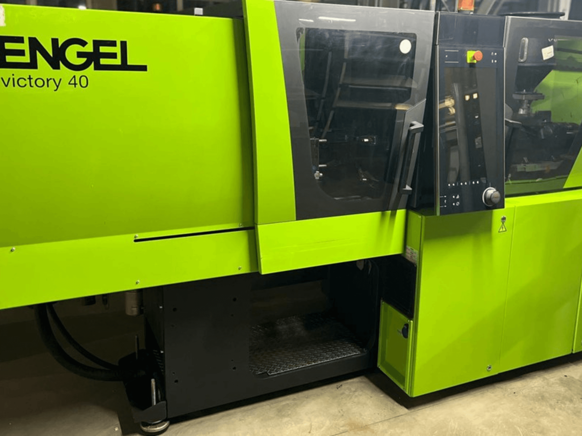 ENGEL Victory 40 Spritzgießmaschine in leuchtendem Grün, Frontansicht mit Bedienfeld und Zugangstür mit Warnschild.