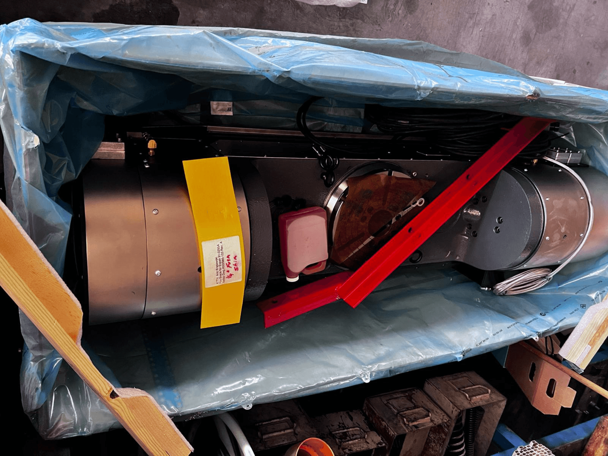 Das Motorgerät ist in der Verpackung teilweise sichtbar, hat ein silbernes Äußeres, bunte Anzeigen und eine rote Stützstrebe.