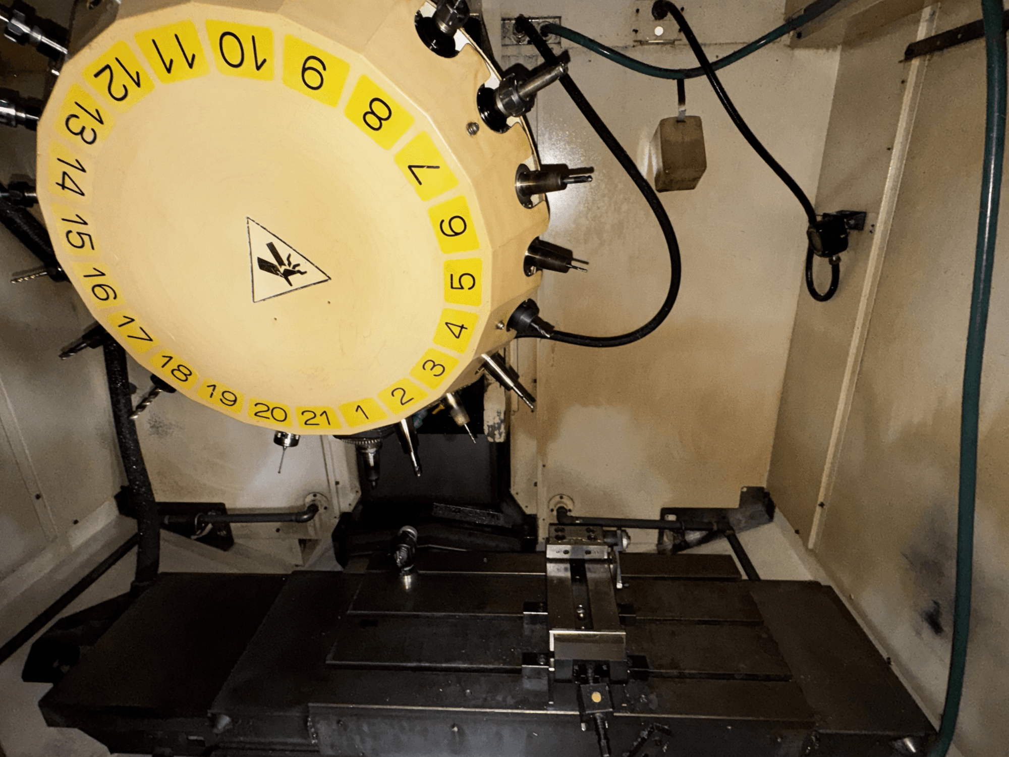 Innenansicht des vertikalen Bearbeitungszentrums FANUC Robodrill alpha-T21iFL mit Werkzeugkarussell und Bearbeitungstisch.