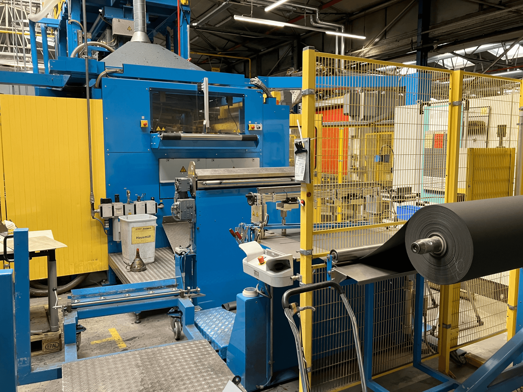 KIEFEL Kunststoffverarbeitungsmaschine KLS 86/235 von vorne gesehen, mit schwarzer Materialrolle und Bedienfeld.