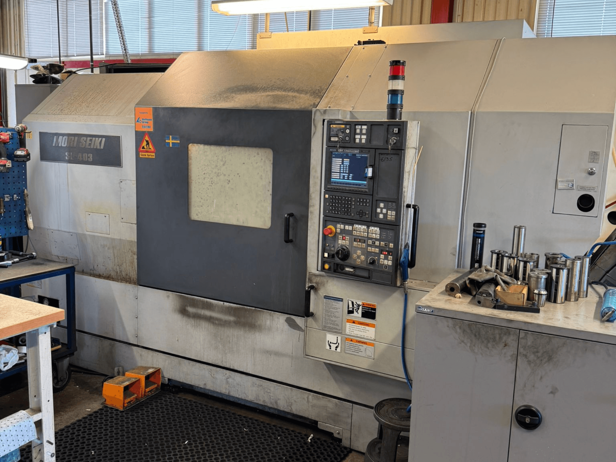MORI SEIKI SL-403BMC/800 Horizontal-Drehmaschine in einer Werkstatt, mit Bedienfeld und Werkzeugen in der Nähe, Seitenansicht.