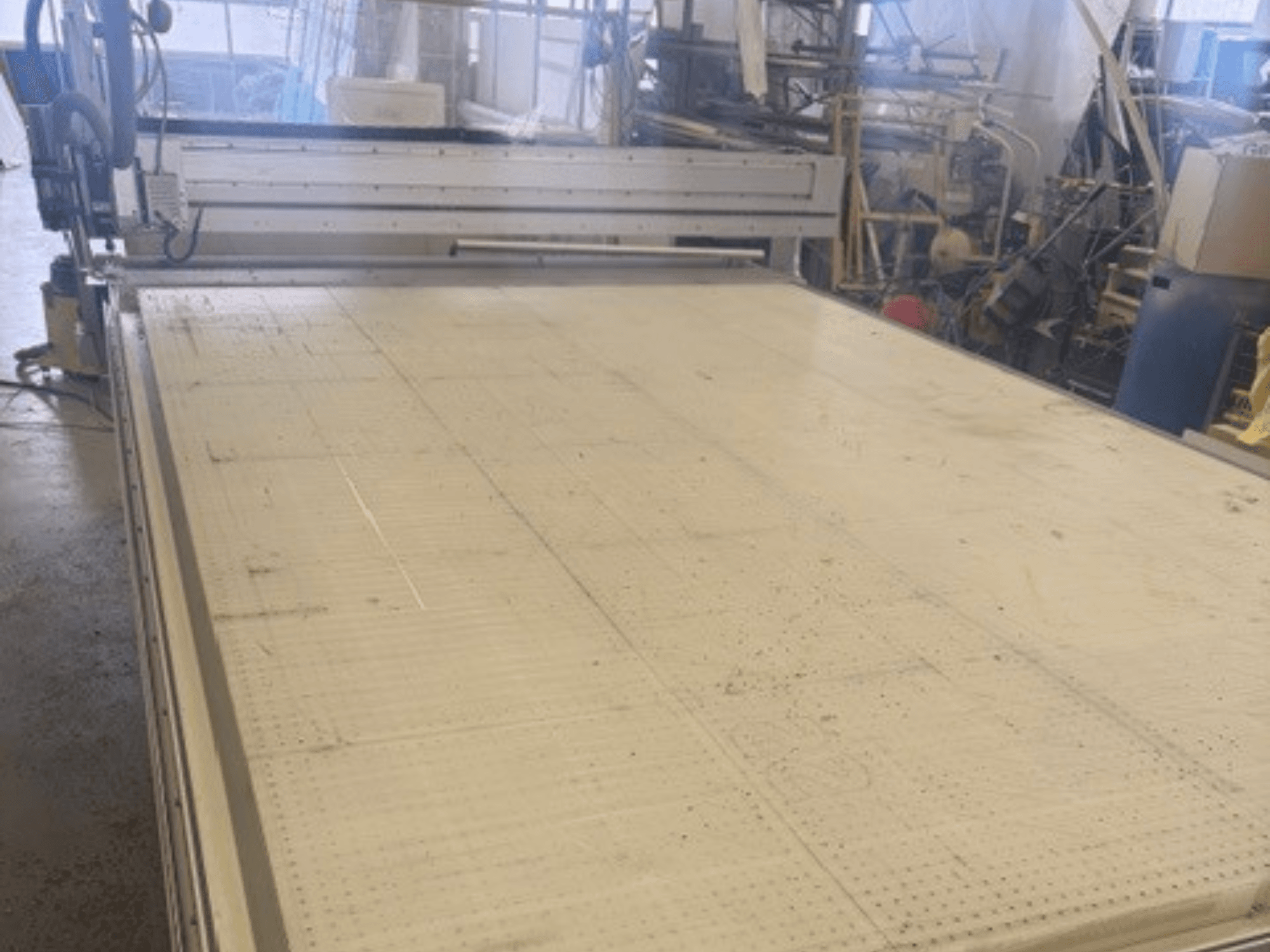 Große Schneidemaschine mit einer ebenen Fläche, die den Rahmen und die Führungsschiene zeigt; Ansicht aus einem Winkel in einer Werkstatt.