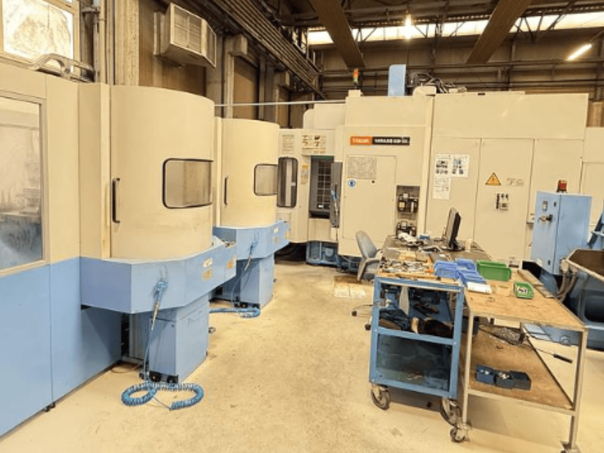 Mazak Variaxis 630-5X Vertikal-Bearbeitungszentrum in einer Werkstatt, Vorderansicht mit Bedienfeld und Werkzeugablagebereich.