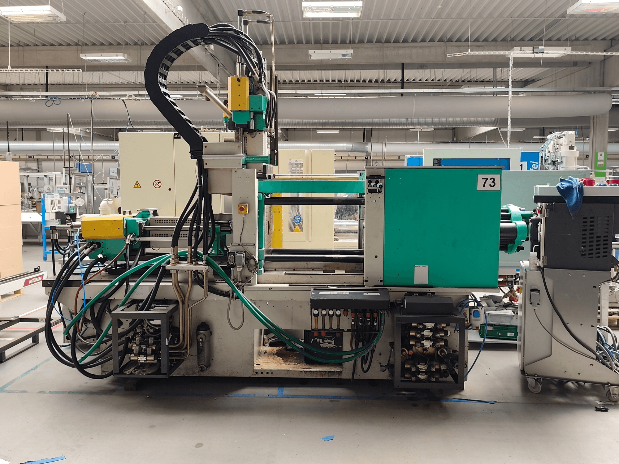 Hydraulische Spritzgießmaschine, Arburg 420 C 1000-150/60, Seitenansicht, mit sichtbaren Hydraulikanschlüssen und Bedienelementen.