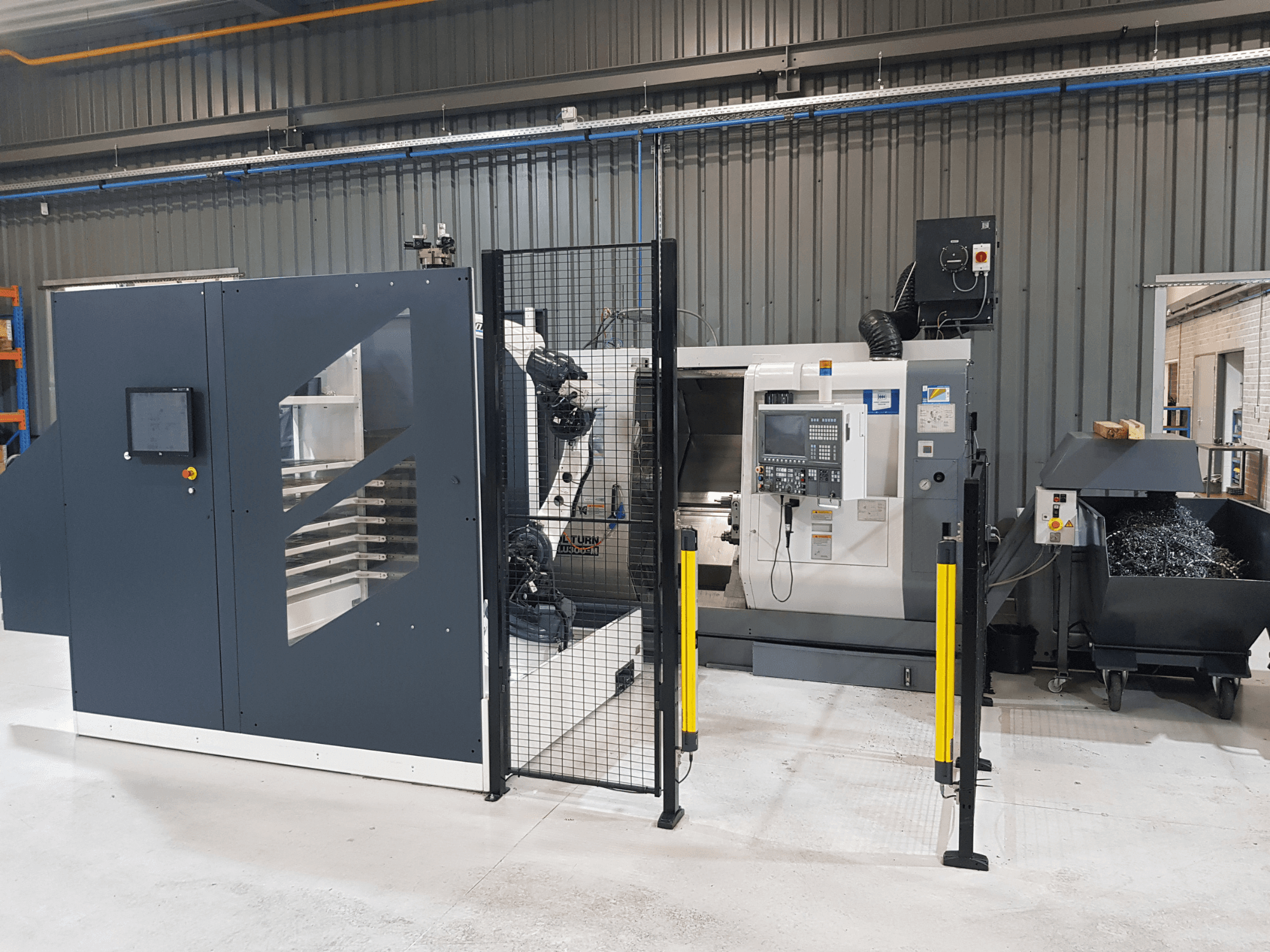 ALTURN-Drehautomat und CNC-Maschine in einer Werksumgebung; Vorderansicht mit Bedienfeld und Sicherheitsabdeckung sichtbar.