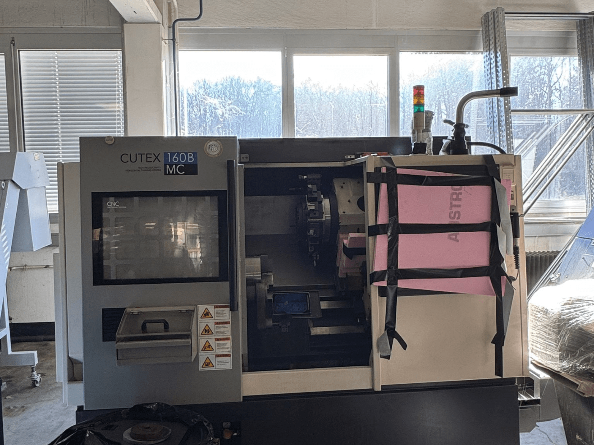 Vorderansicht der horizontalen Drehmaschine HWACHEON CUTEX 160 B VDI mit Bedienfeld und Kühlmitteltank, ausgestattet mit einer Sicherheitsleuchte.