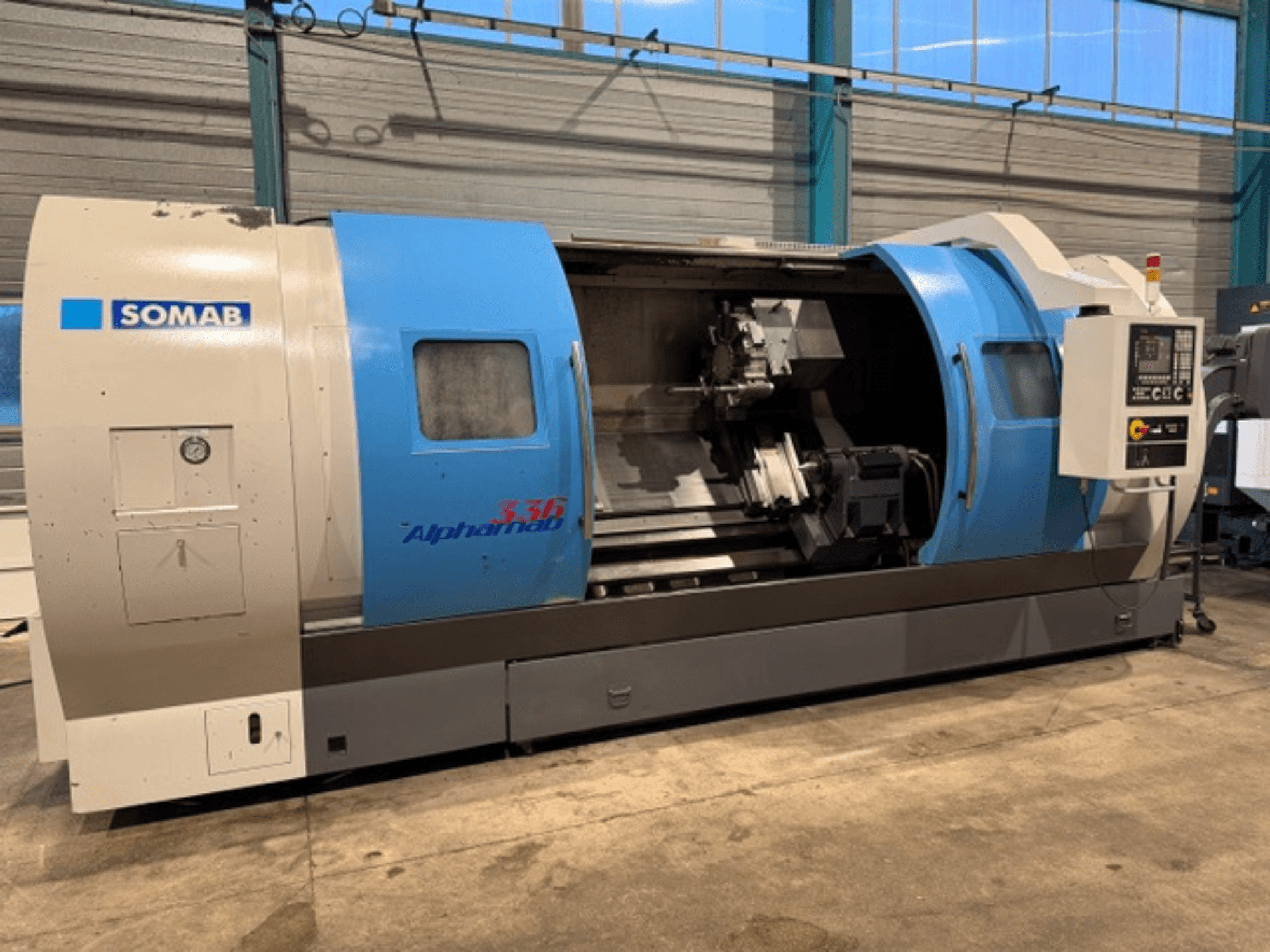 SOMAB Alpha 336 CNC-Drehmaschine, Vorderansicht, mit blauem und grauem Gehäuse und seitlichem Bedienfeld für die Bedienung.
