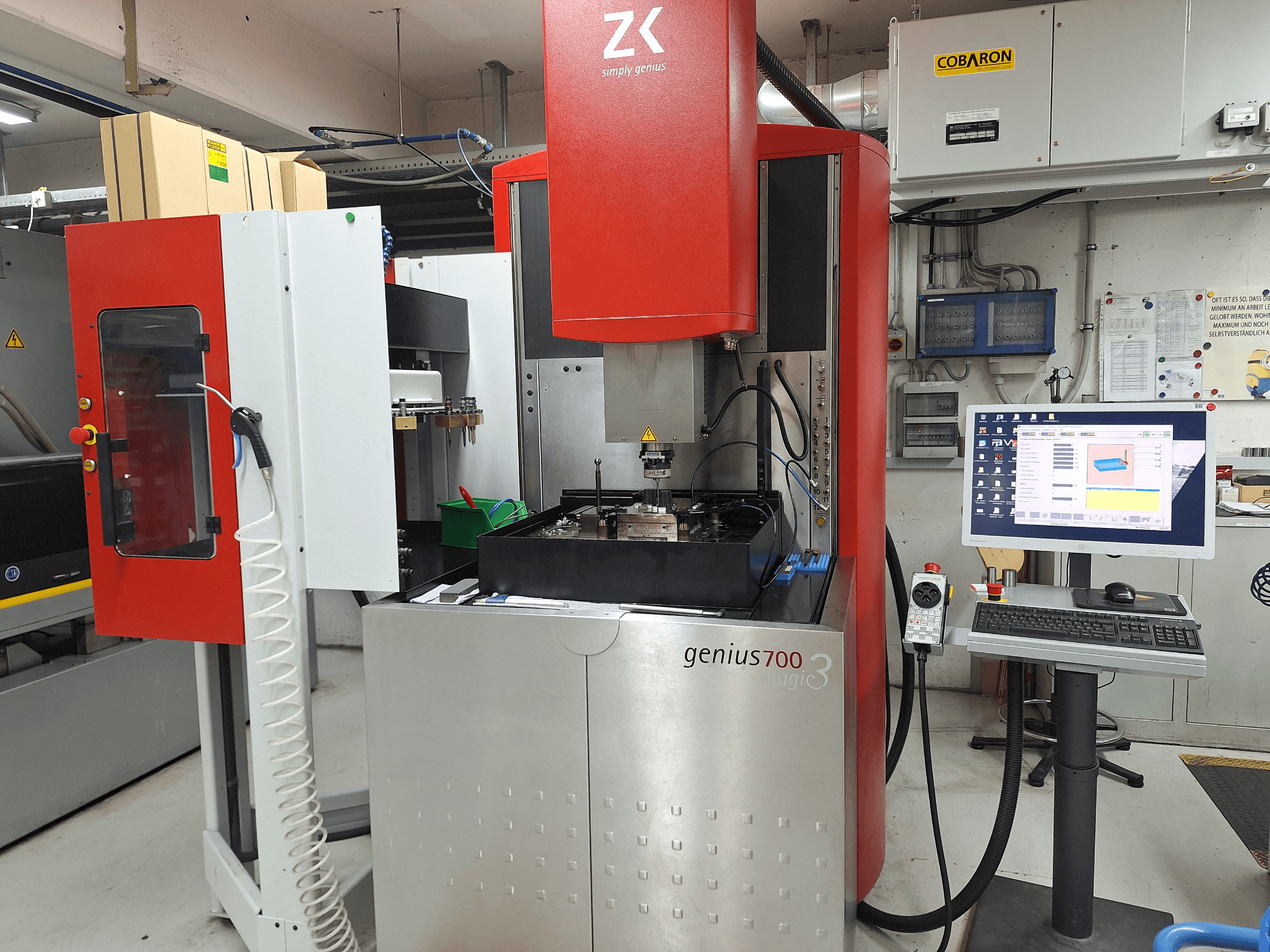 Genius 700 Fräsmaschine von ZK, Frontansicht, mit Touchscreen-Bedienfeld und Bearbeitungsbereich mit Werkzeugen und Materialien.