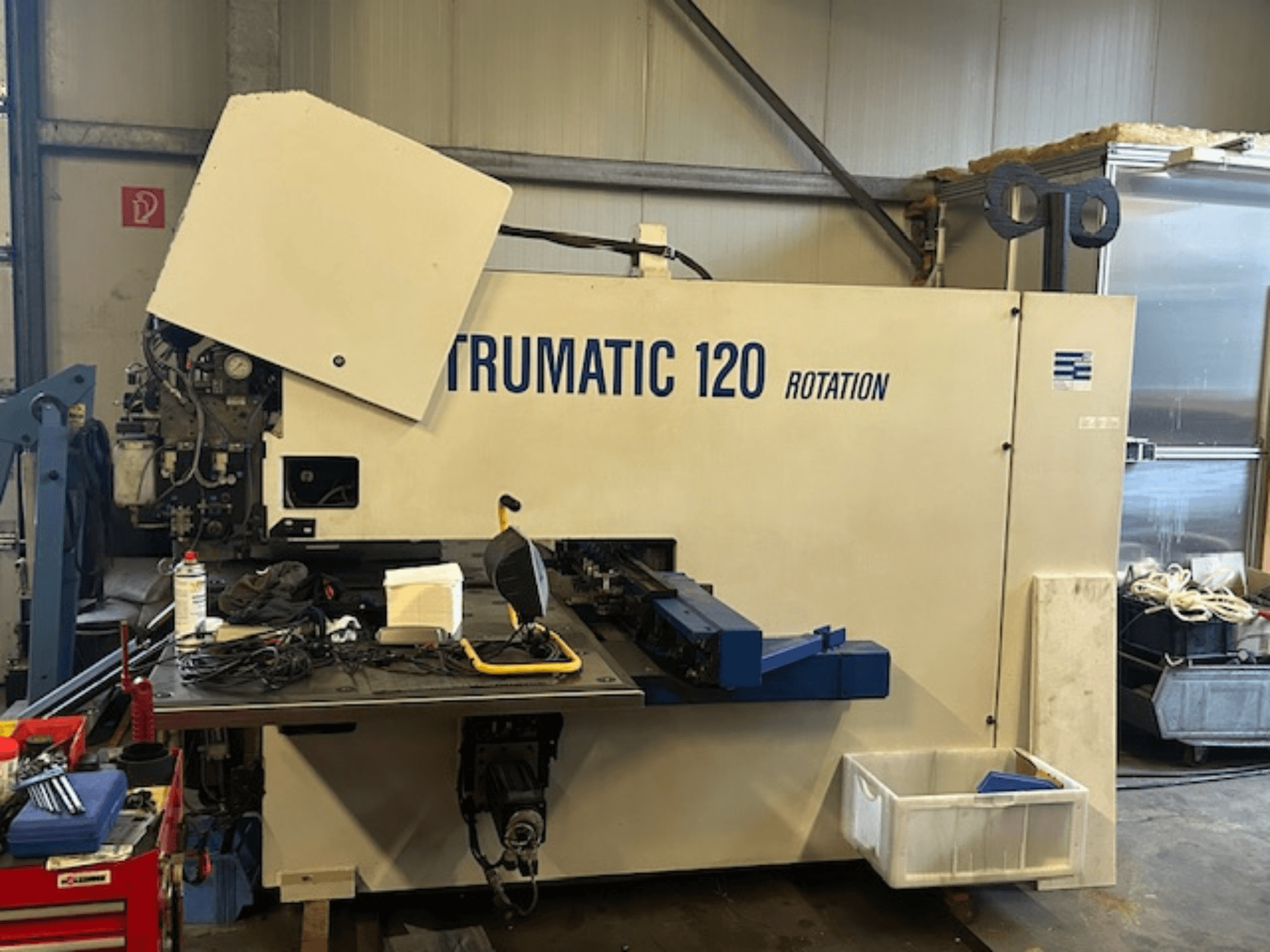 TRUMPF Trumatic 120R CNC-Stanzmaschine in einer Werkstatt, Frontansicht mit Bedienfeld und Werkzeugen auf dem Tisch.