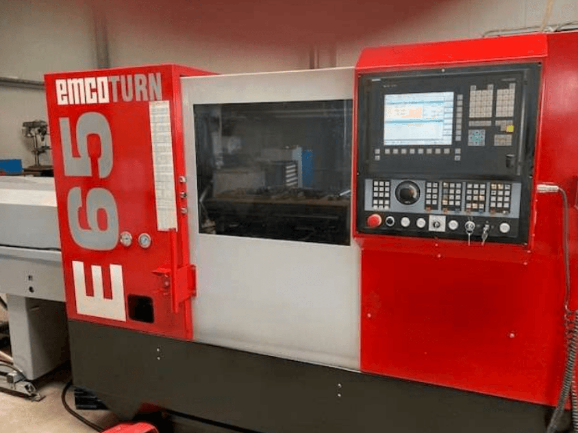 EMCO Turn E65 CNC-Drehmaschine, Vorderansicht mit Bedienfeld, großem Display und Arbeitsbereich hinter Glas.