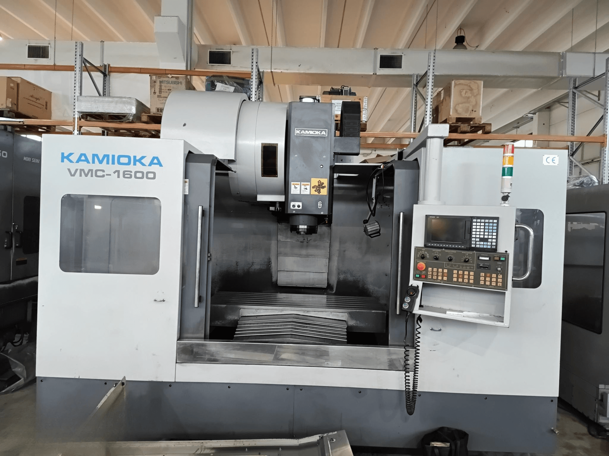 Kamioka VMC-1600 Vertikal-Bearbeitungszentrum in einer Fabrikumgebung, Vorderansicht mit Bedienfeld und sichtbarem Bearbeitungsbett.