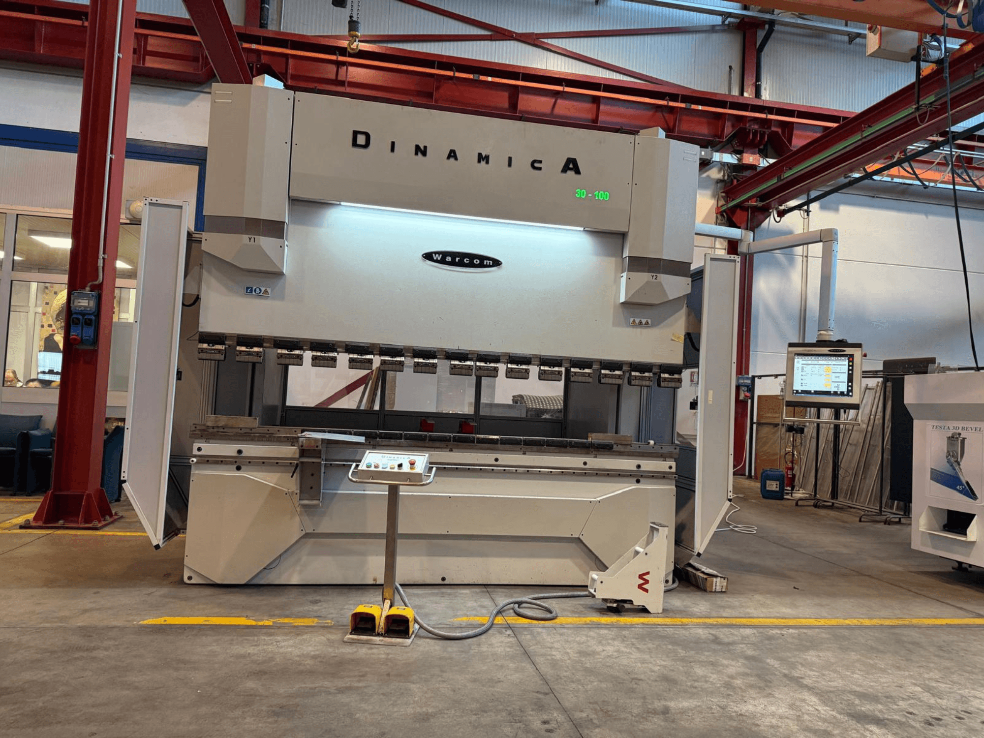 Hydraulische Abkantpresse Dinamica Warcom, Vorderansicht. Mit Bedienfeld und mehreren Werkzeugstationen für Präzisionsbiegungen.