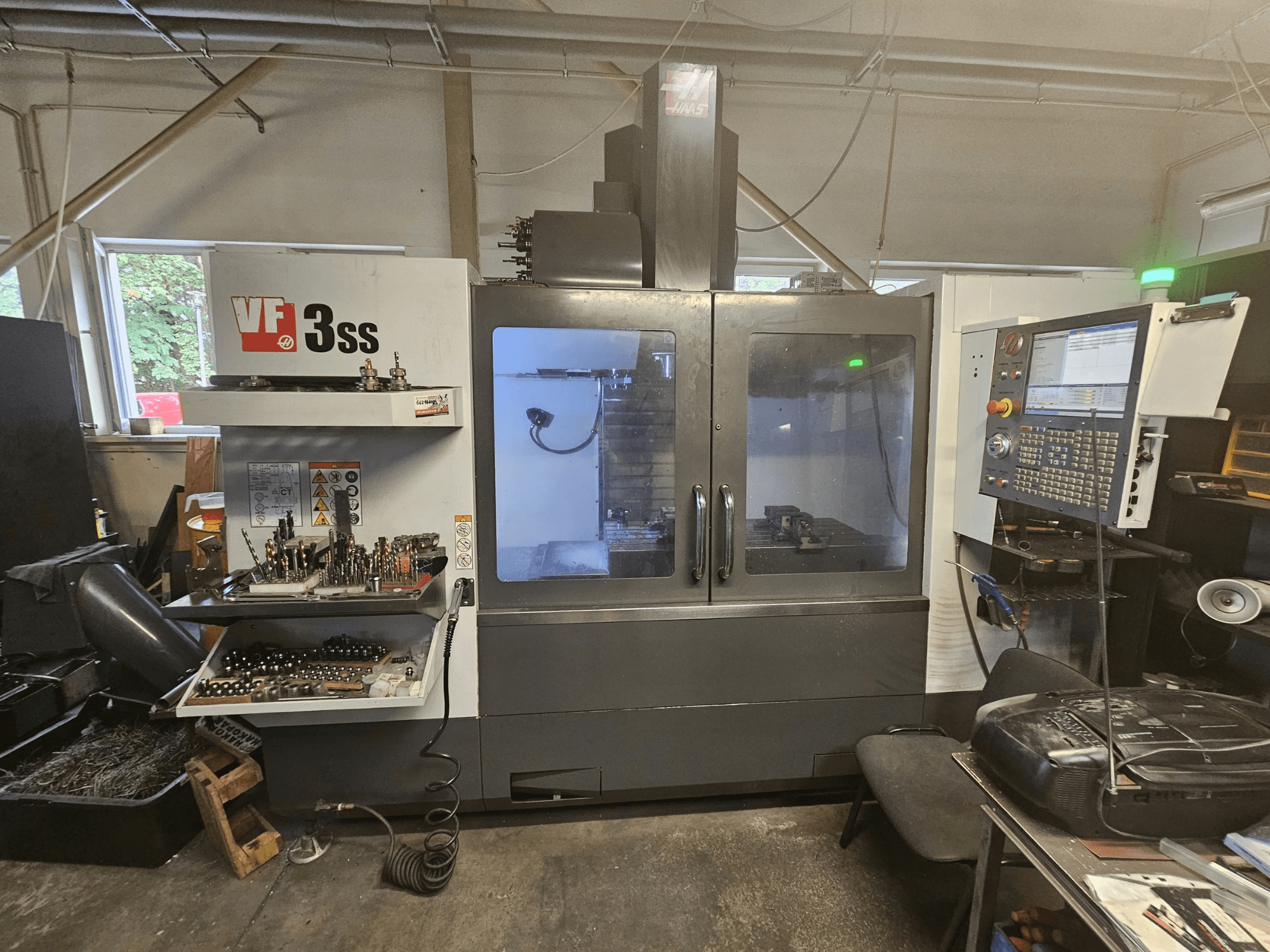 Vertikales Bearbeitungszentrum Haas VF-3SS in einer Werkstatt, Vorderansicht mit Bedienfeld und Werkzeugmagazin.