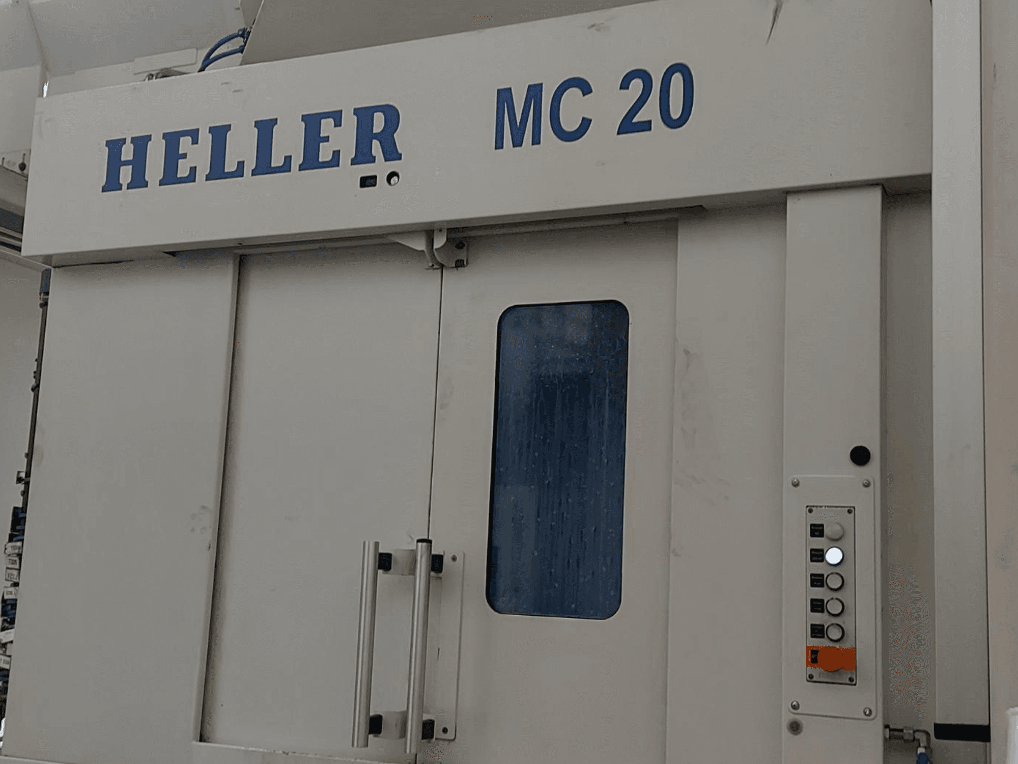 Frontansicht des Horizontal-Bearbeitungszentrums HELLER MC 20 mit Bedienfeld und Frontscheibe.
