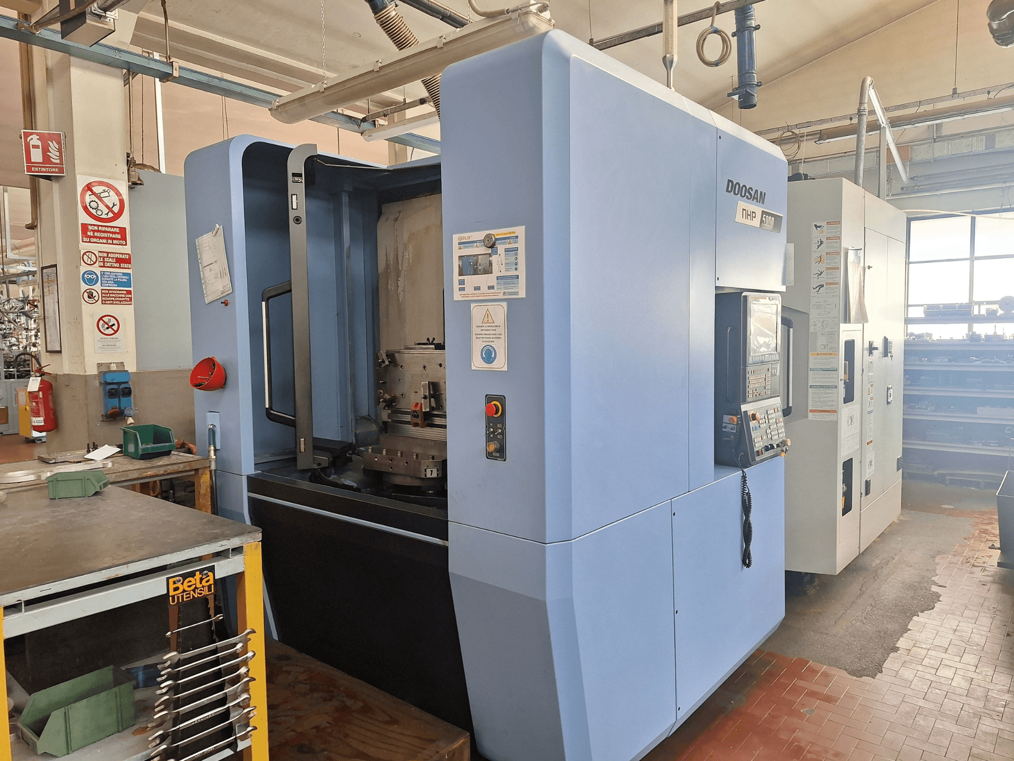 DOOSAN NHP 5000 Horizontal-Bearbeitungszentrum in einer Werkstatt, Seitenansicht mit Bedienfeld und Bearbeitungsbereich.