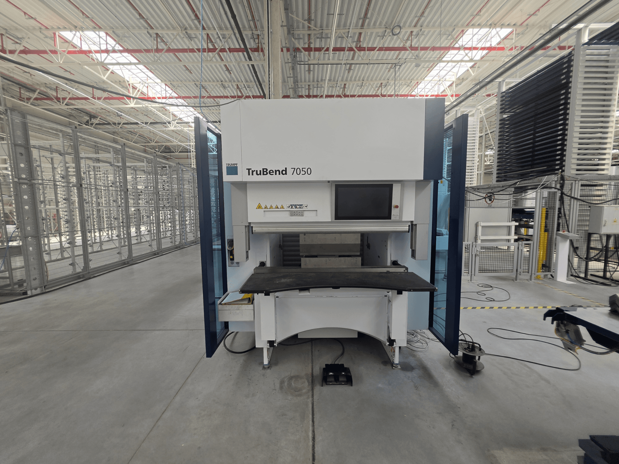 Vorderansicht der TRUMPF TruBend 7050 Abkantpresse mit Blick auf das Bedienpult und den Arbeitstisch in einer gut beleuchteten Industrieumgebung.