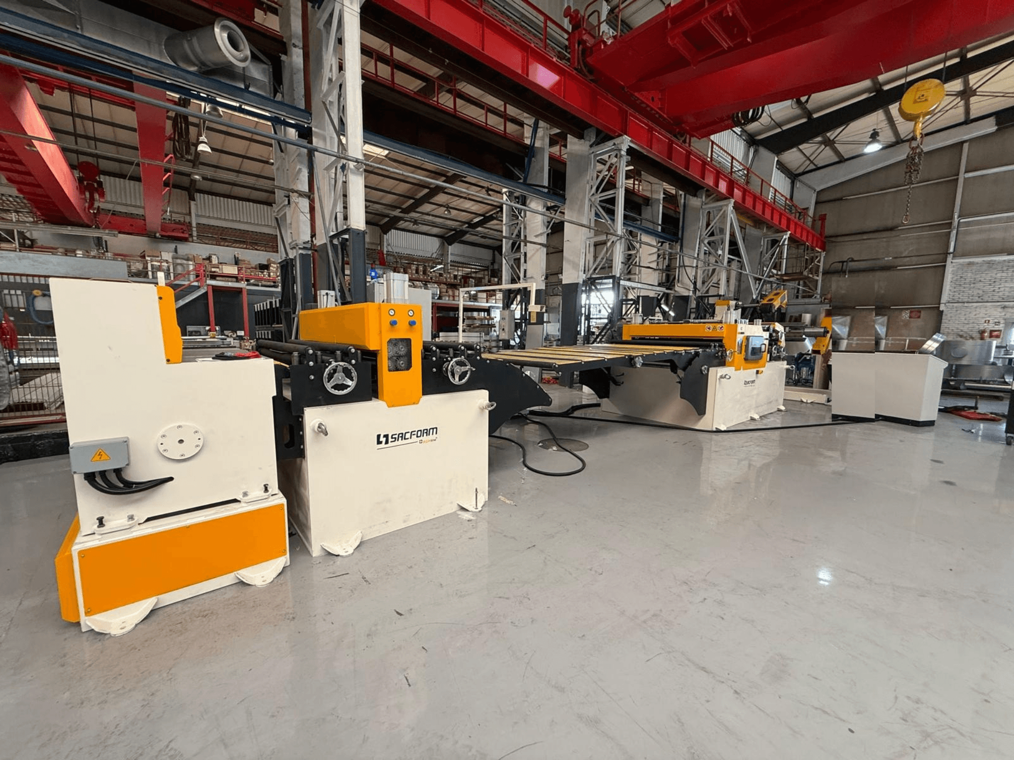 Vorderansicht der Blechbearbeitungsmaschine SACFORM CRL1503-6 mit gelb-weißer Lackierung, Rädern und Bedienelementen.