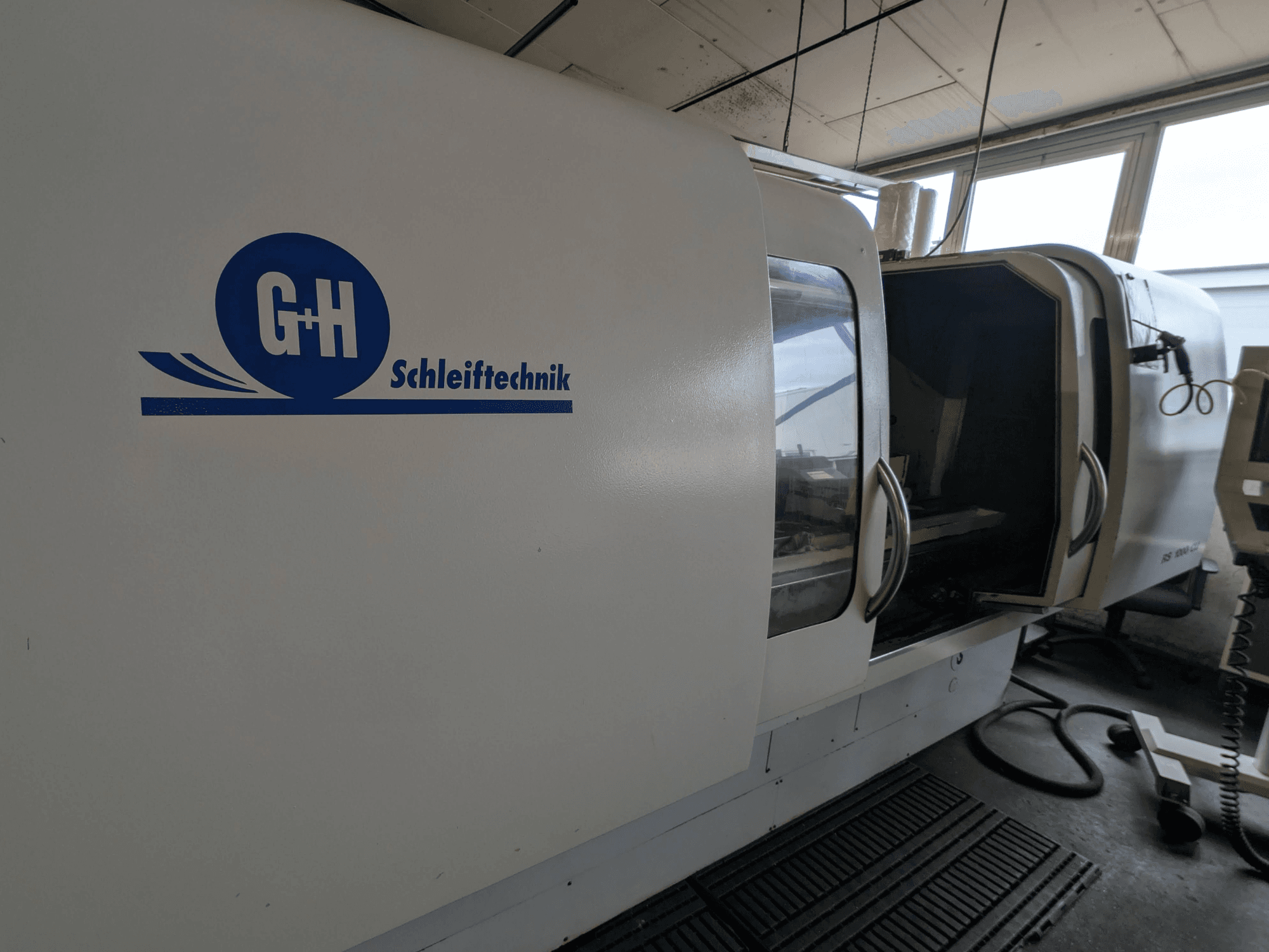 Rundschleifmaschine GEIBEL & HOTZ RS 1000 CU, Seitenansicht mit Bedienfeld und geöffneter Zugangstür.