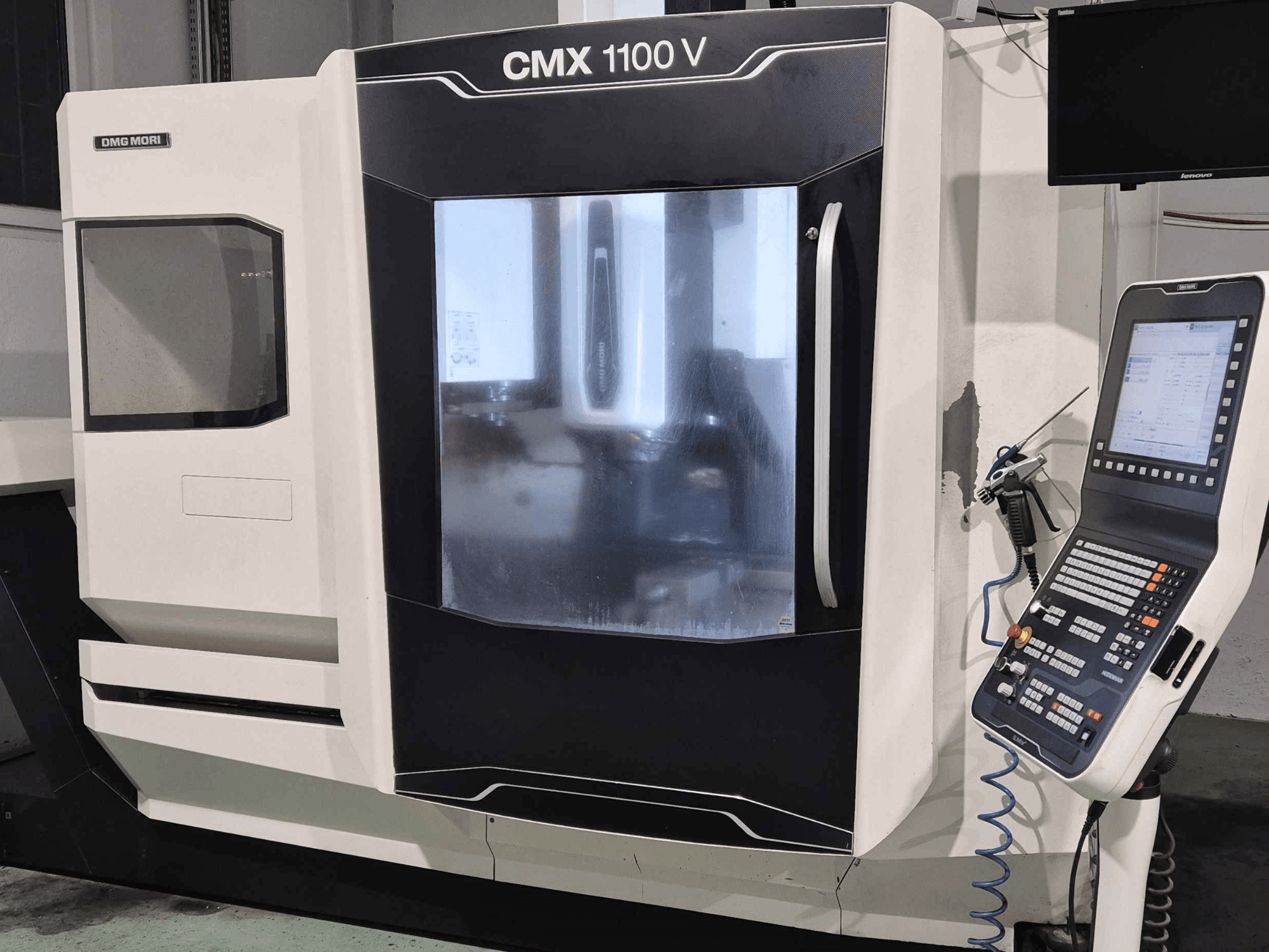 DMG Mori CMX 1100 V, Frontansicht der CNC-Maschine mit Bedienfeld, Digitalanzeige und Kühlmitteleinrichtung.